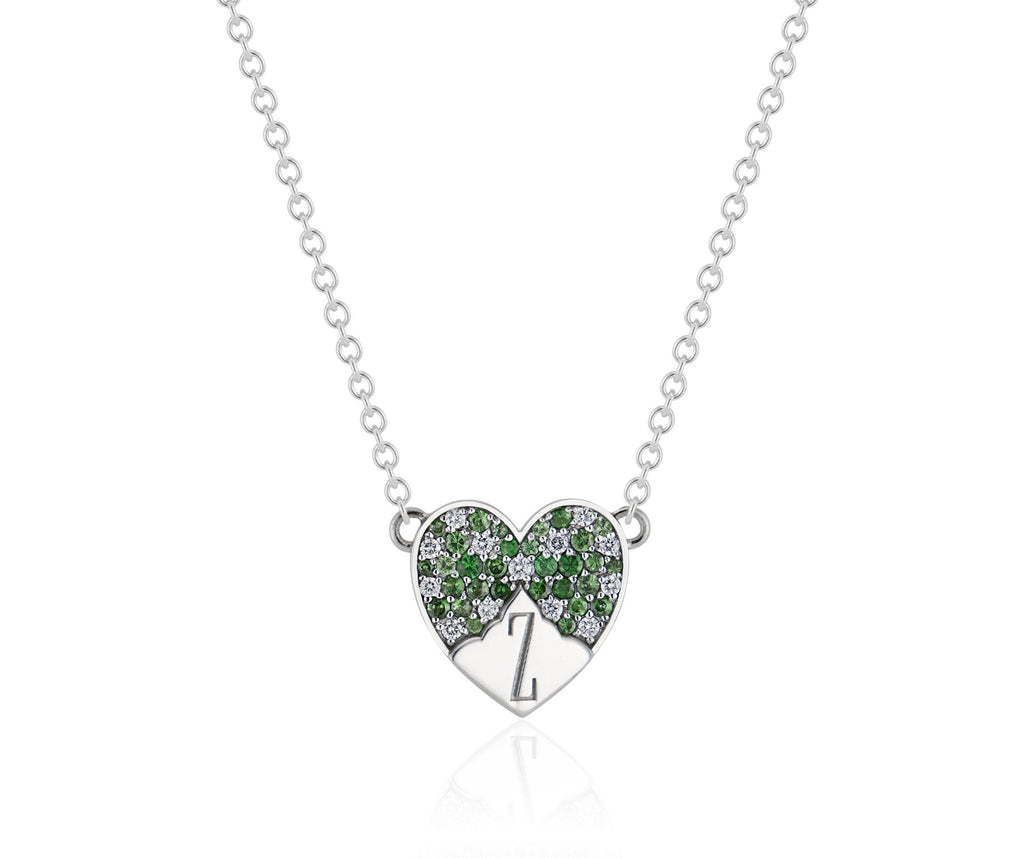 Heart-shaped white gold pendant and chain. Top of the heart is encrusted with alternating diamond and tsavorite stones. A white-gold mountain peak silhouette extends up from the bottom of the heart with an engraved letter Z reaching point to point.