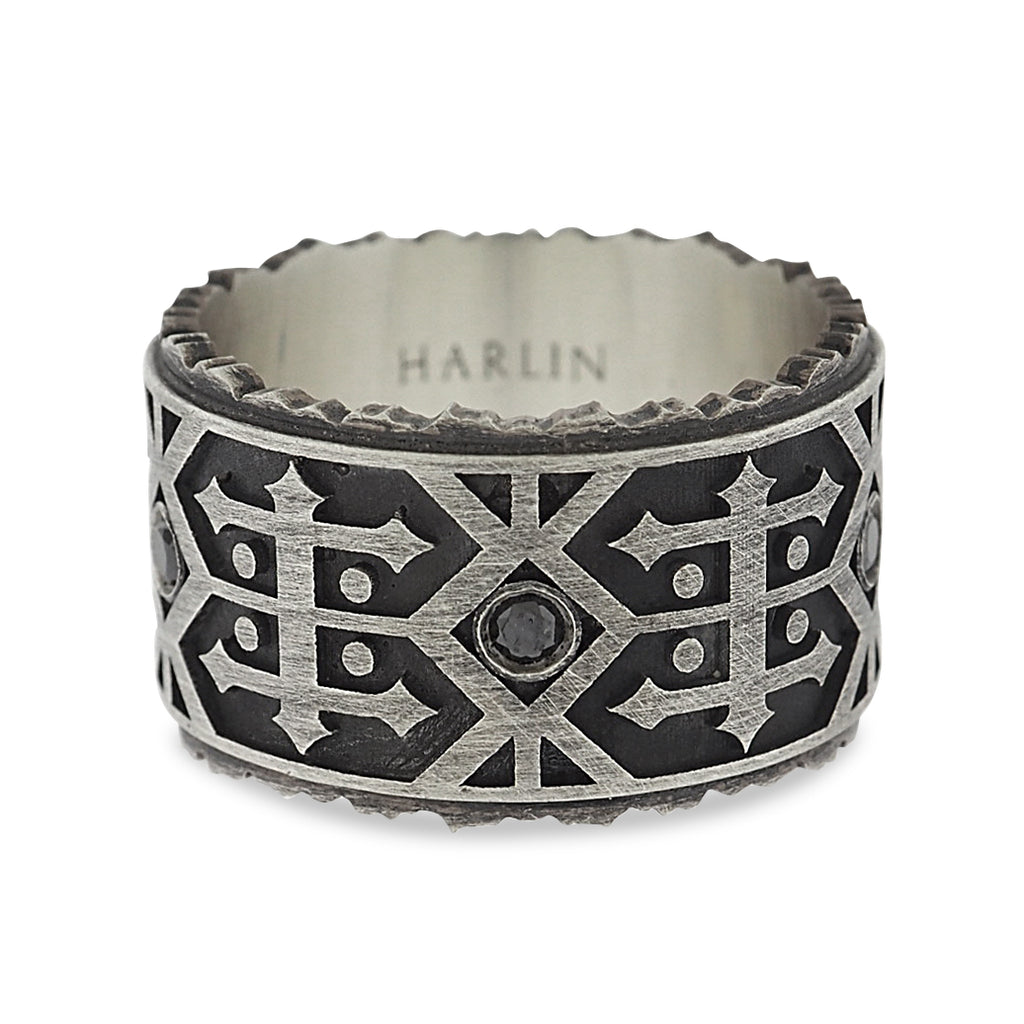 Side view of black diamond wedding band. Oxidized silver irregular edges at the ring’s top and bottom appear as the jagged peaks of a mountain range. The textured matte-finished base provides definition for the polished Navajo-inspired detail.