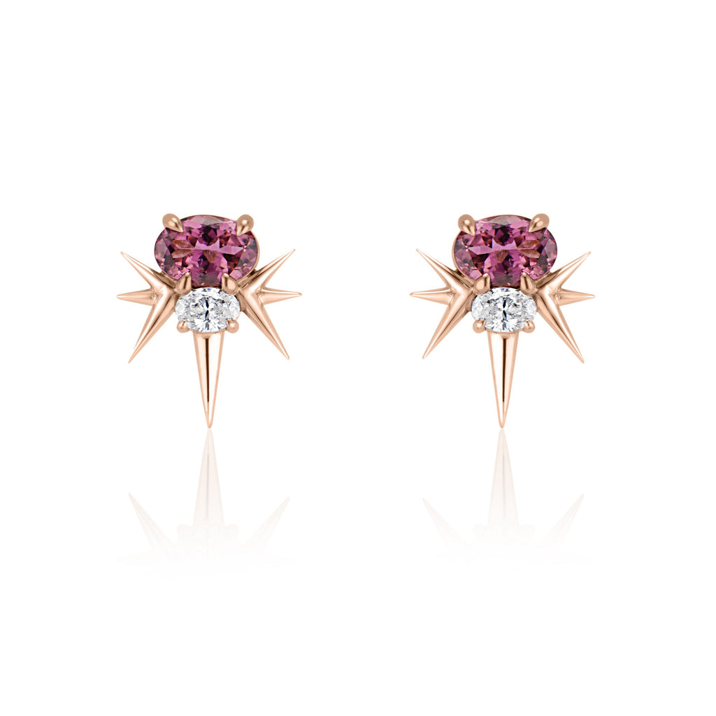  Front view of rose gold spike earrings, each featuring 1 horizontal oval-shaped pink tourmaline stone with 1 oval-shaped diamond below. 7 rose gold spikes extend out from the diamond, 3 on either side and 1 slightly longer spike pointed down. 