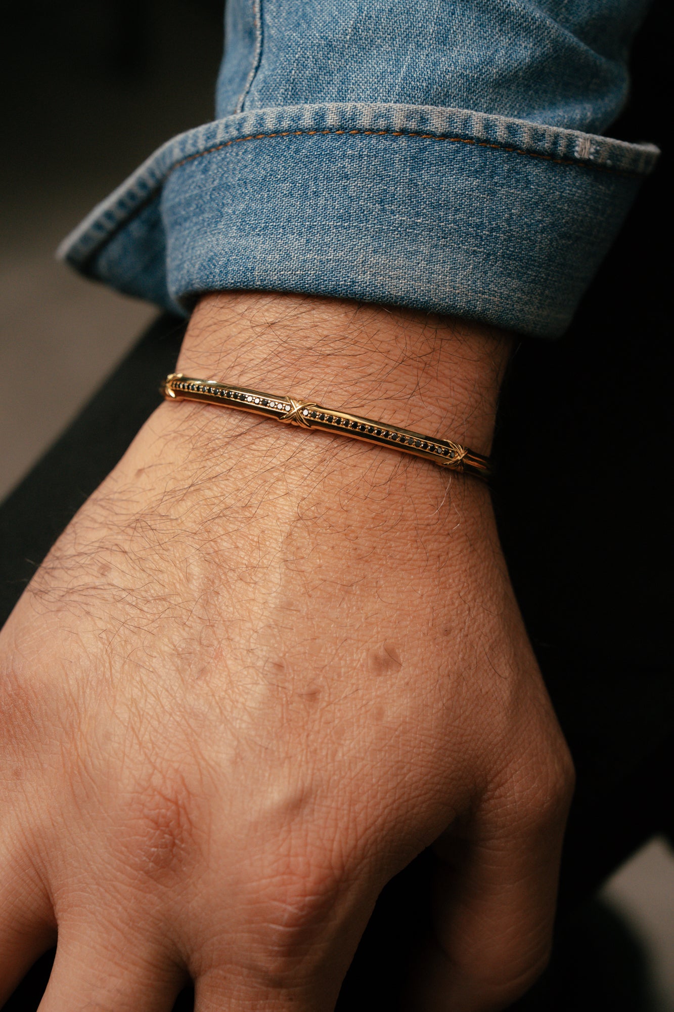 Gold bracelet on a wrist with a blurred background