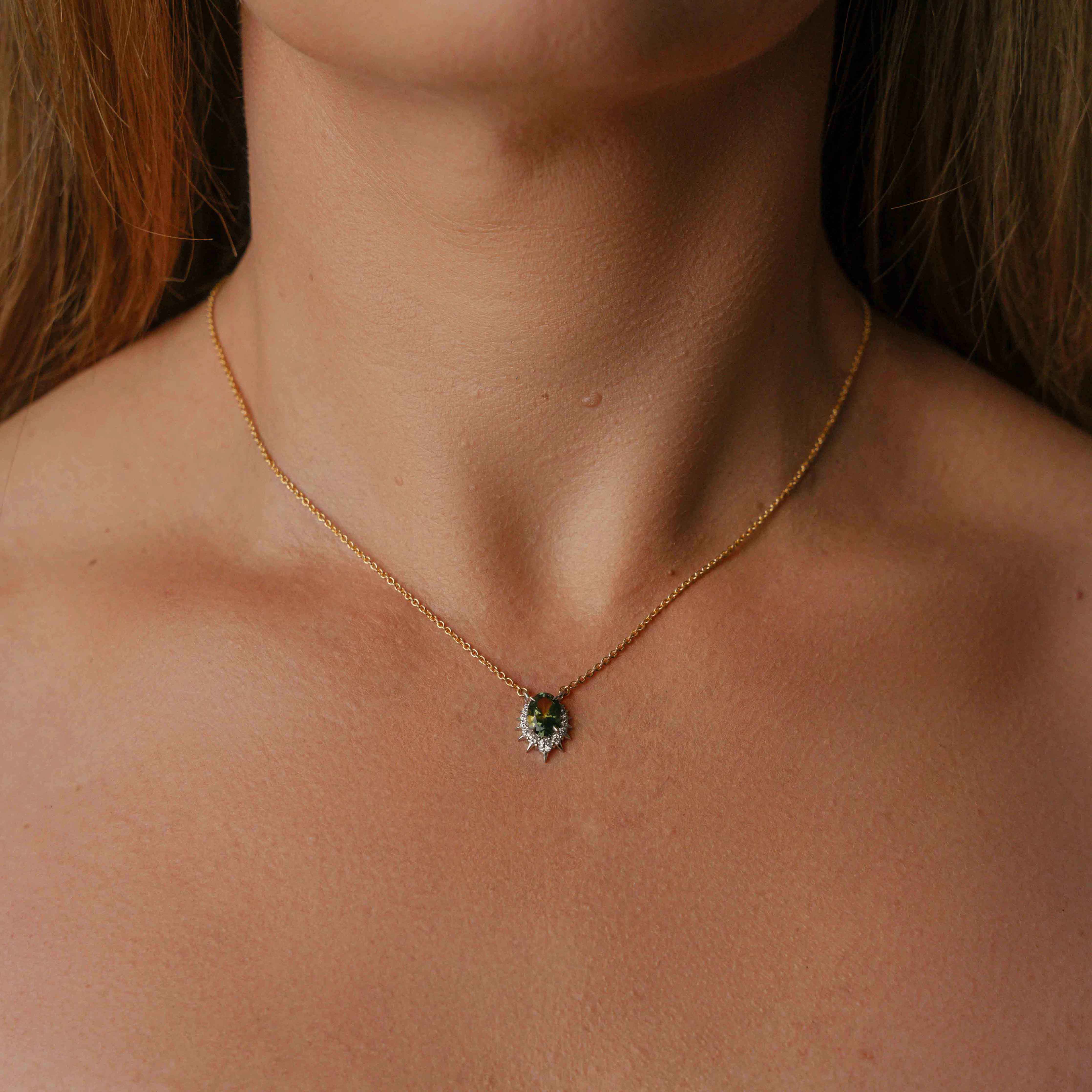 Model wearing parti sapphire necklace with a central oval Australian parti sapphire surrounded by sparkling diamonds.
