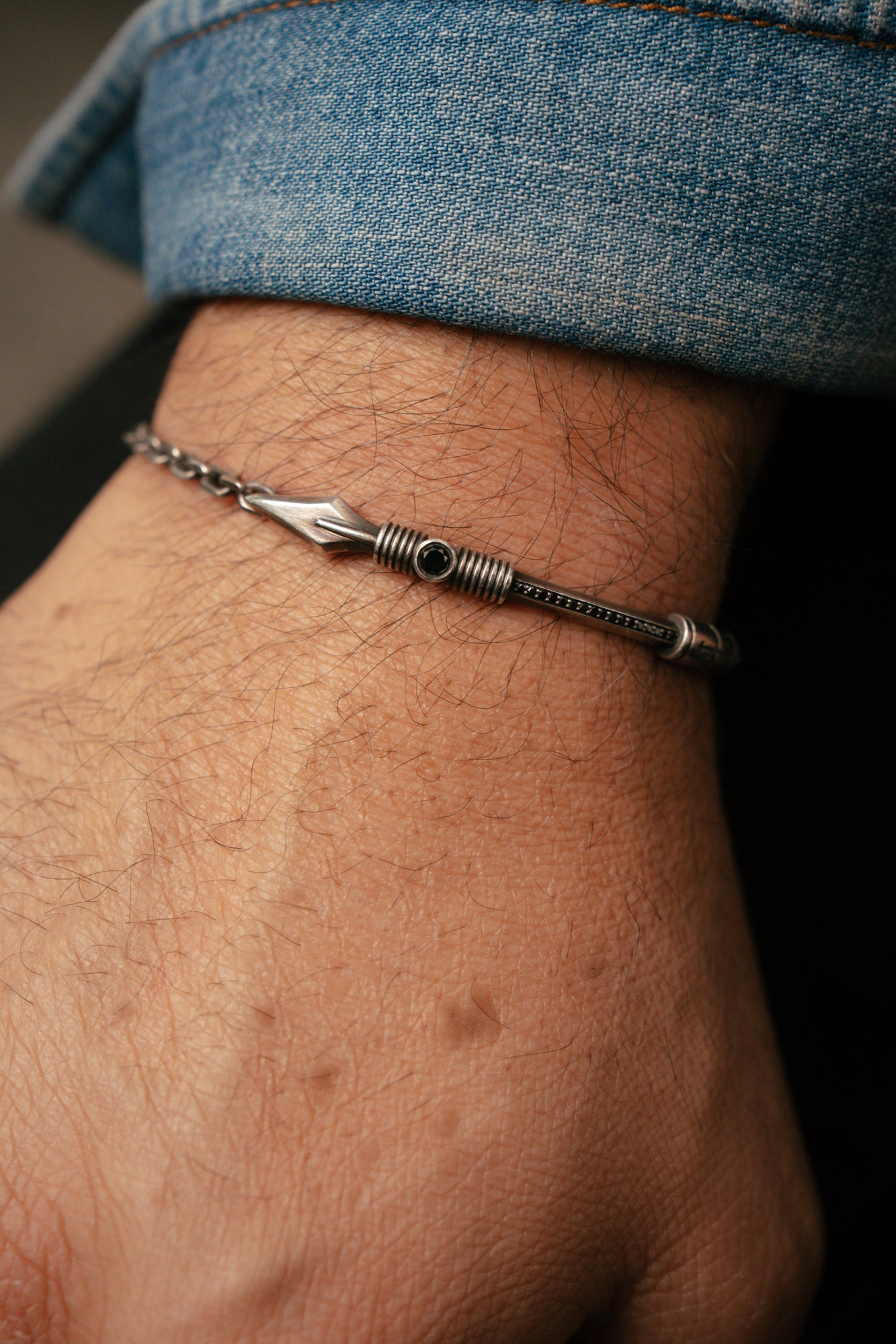 Silver bracelet on a wrist with a blurred background