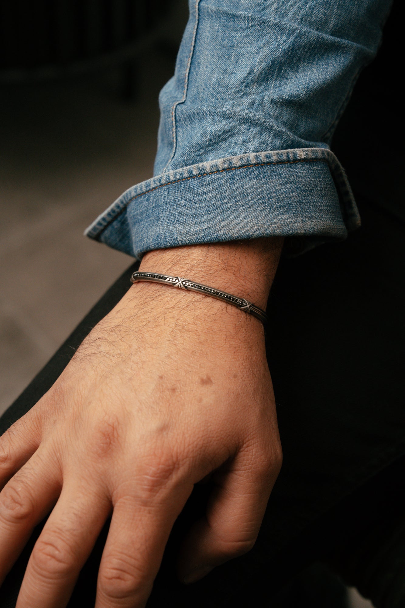 Close-up of a hand wearing a bracelet with a blurred background