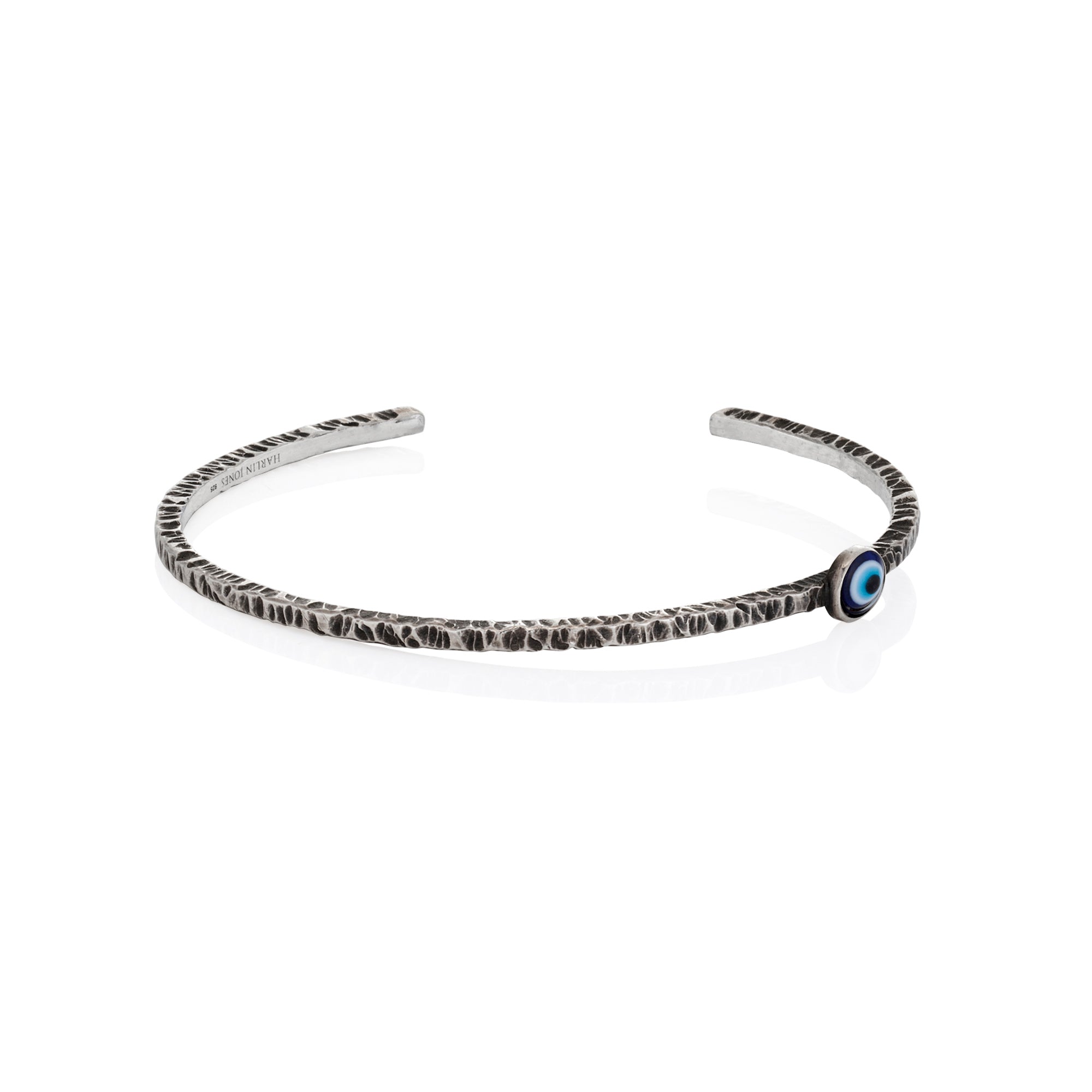 Silver headband with a blue eye charm on a white background
