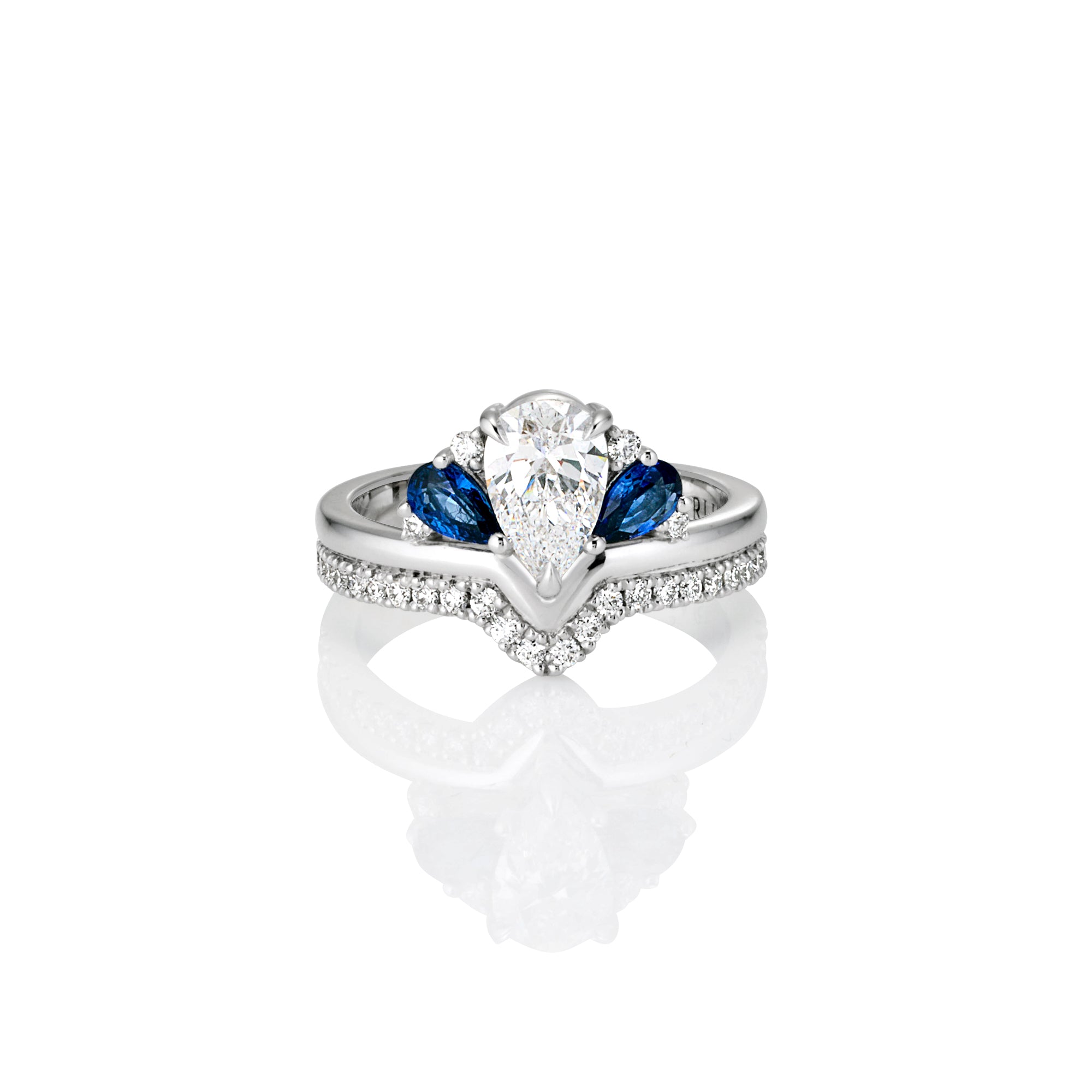 Engagement ring white gold with a central large pear-shaped white diamond, flanked by  blue sapphires, and a band encrusted with small sparkling diamond