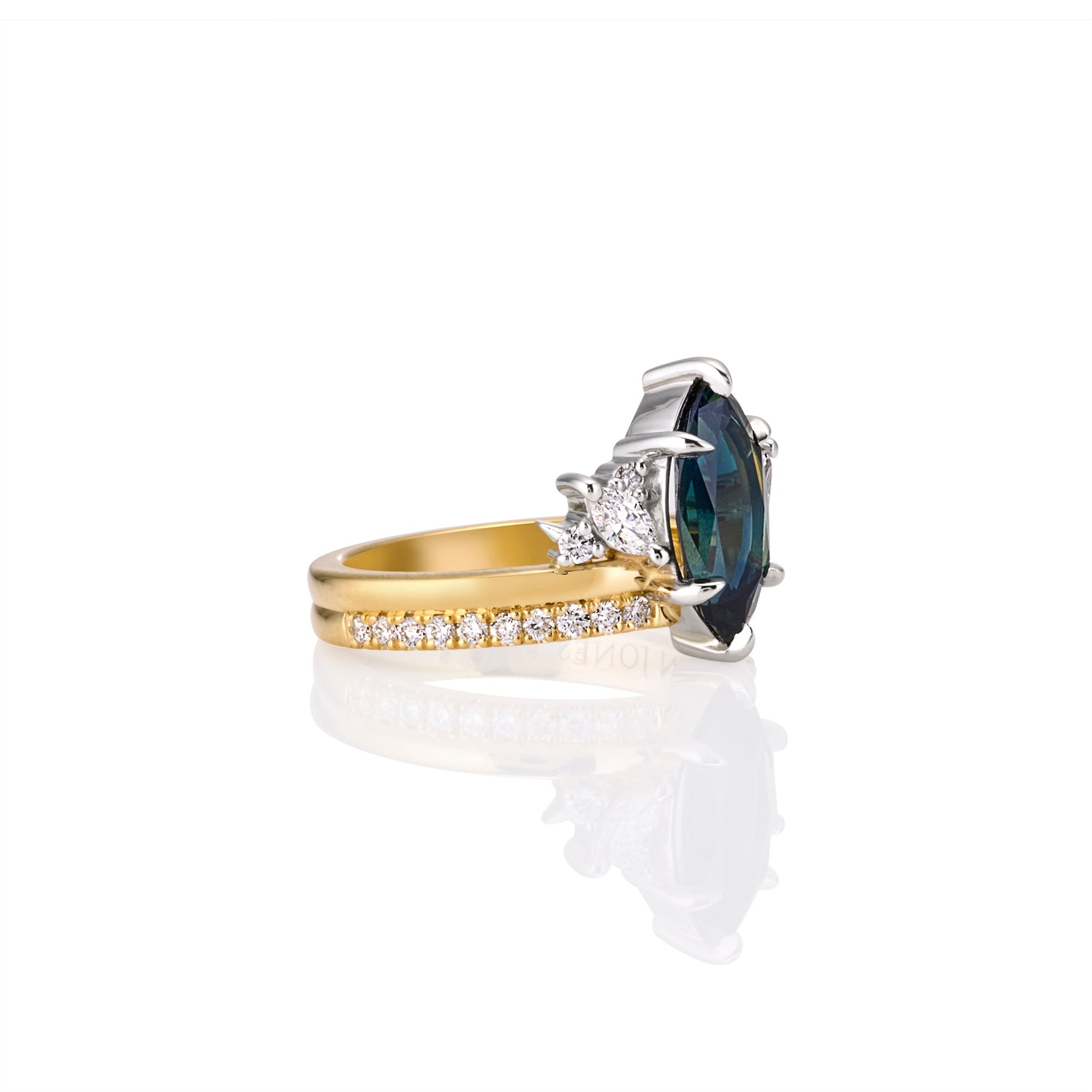 Side angle showing two stacked gold rings with teal australian sapphire and white diamonds 