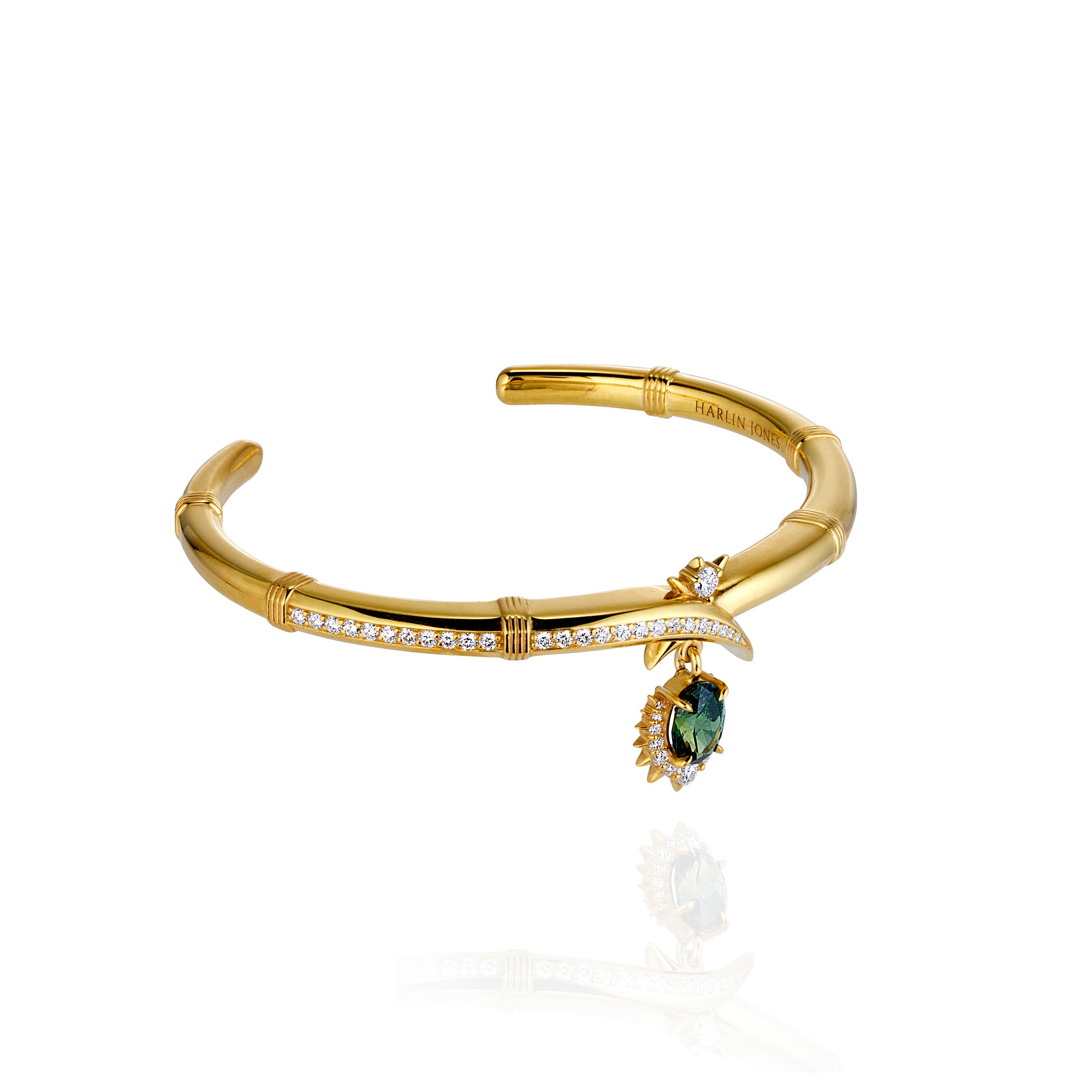 Elegant gold bracelet showcasing a central green stone, embellished with sparkling diamonds on the sides.
