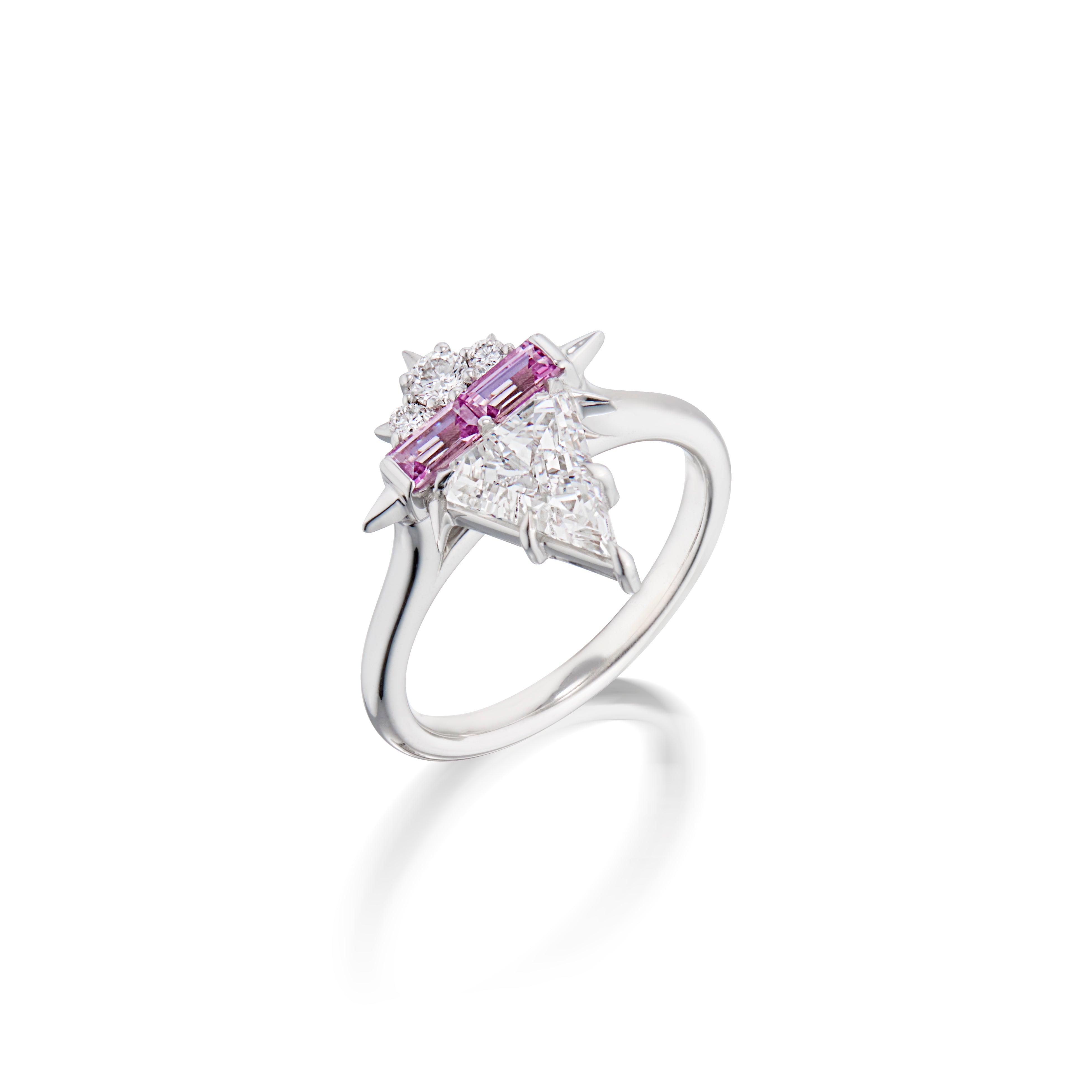 White gold ring with pink gemstones flanked by triangular diamonds on a white background.