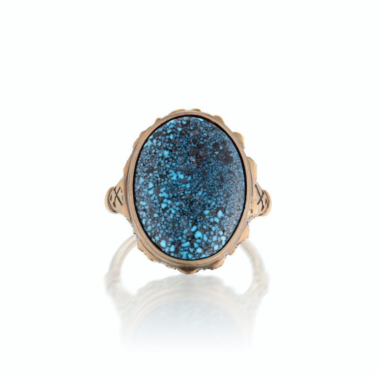 A men's wedding band featuring a blue turquoise centerpiece and black diamond accents set in a yellow gold band with a textured finish.