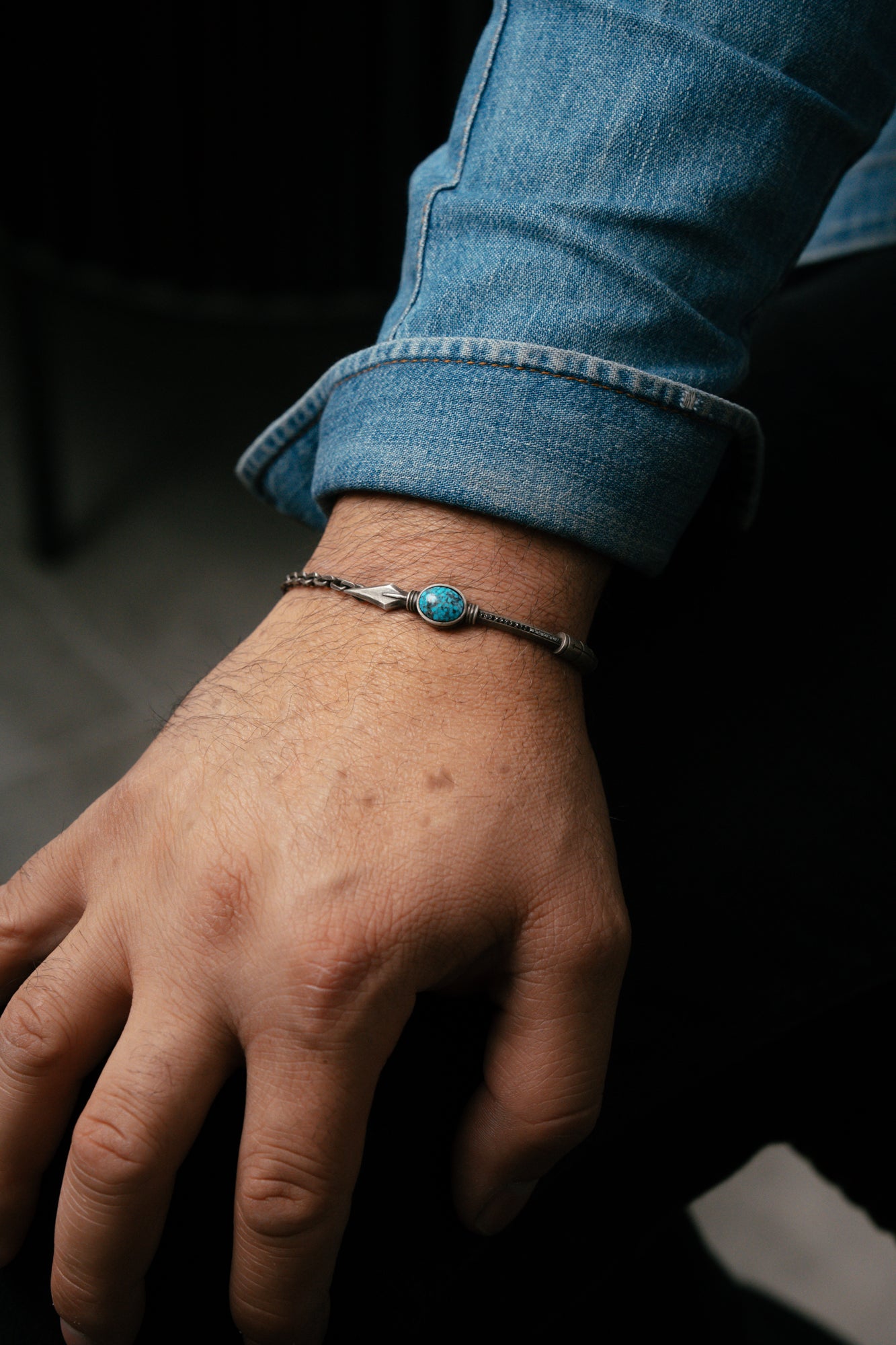 Close-up of a wrist wearing a bracelet with a dark background