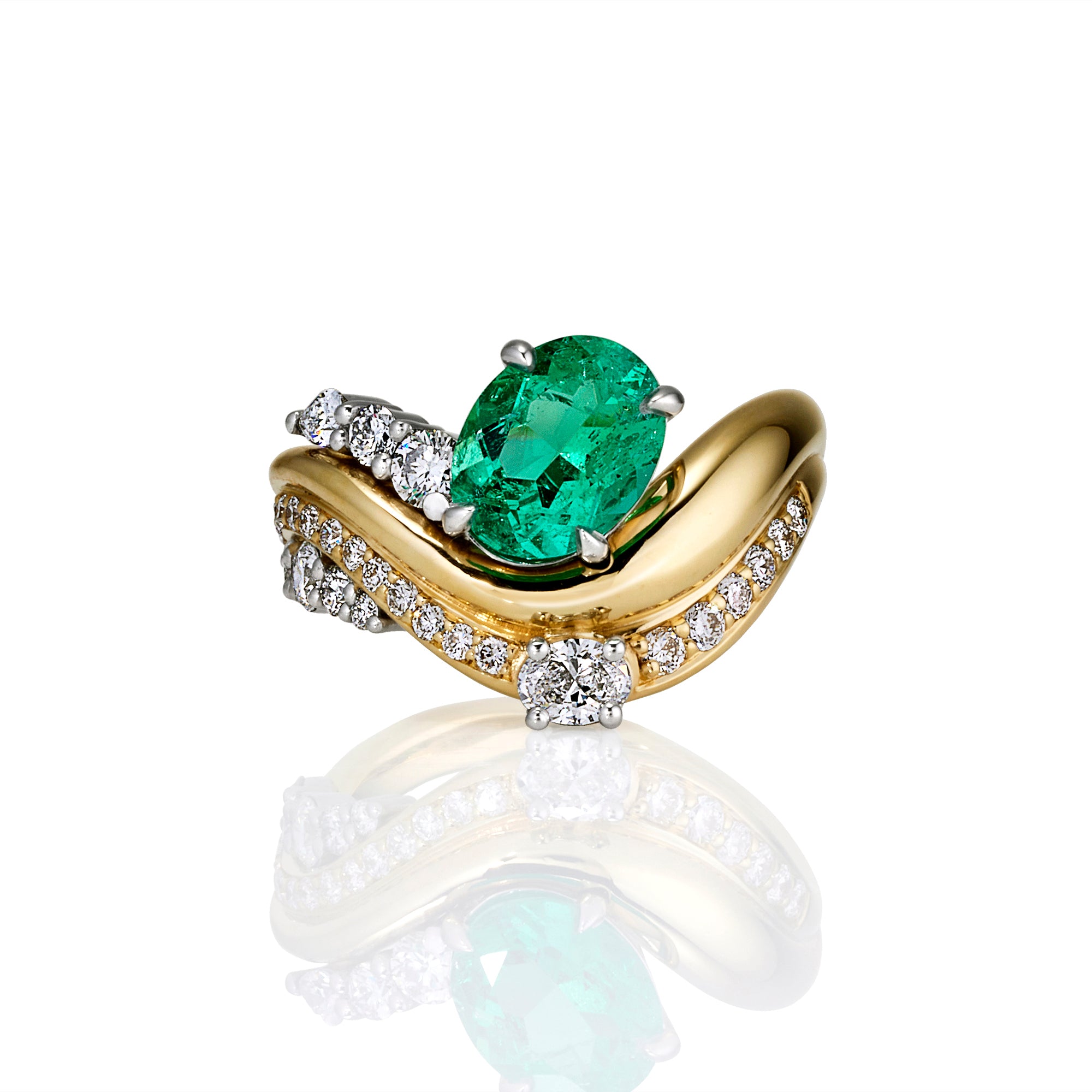 A yellow gold ring featuring a large oval-cut green emerald center stone, accented by pavé-set white diamonds along a curved band, shown on a white background with a soft reflection below.