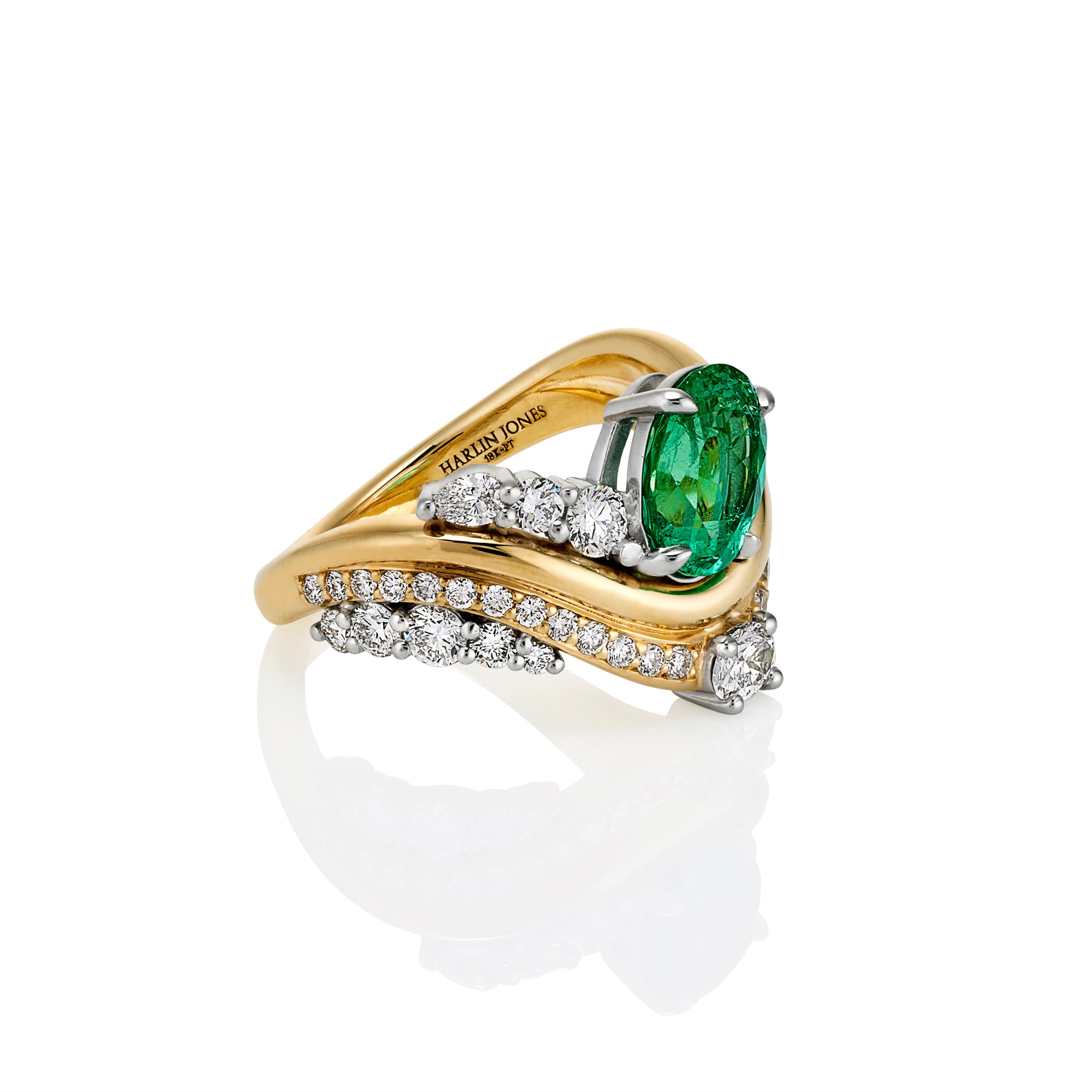 A yellow gold and white gold ring featuring a large oval-cut green emerald gemstone, accented with pavé-set round diamonds along curved bands, shown on a white background with a soft reflection.