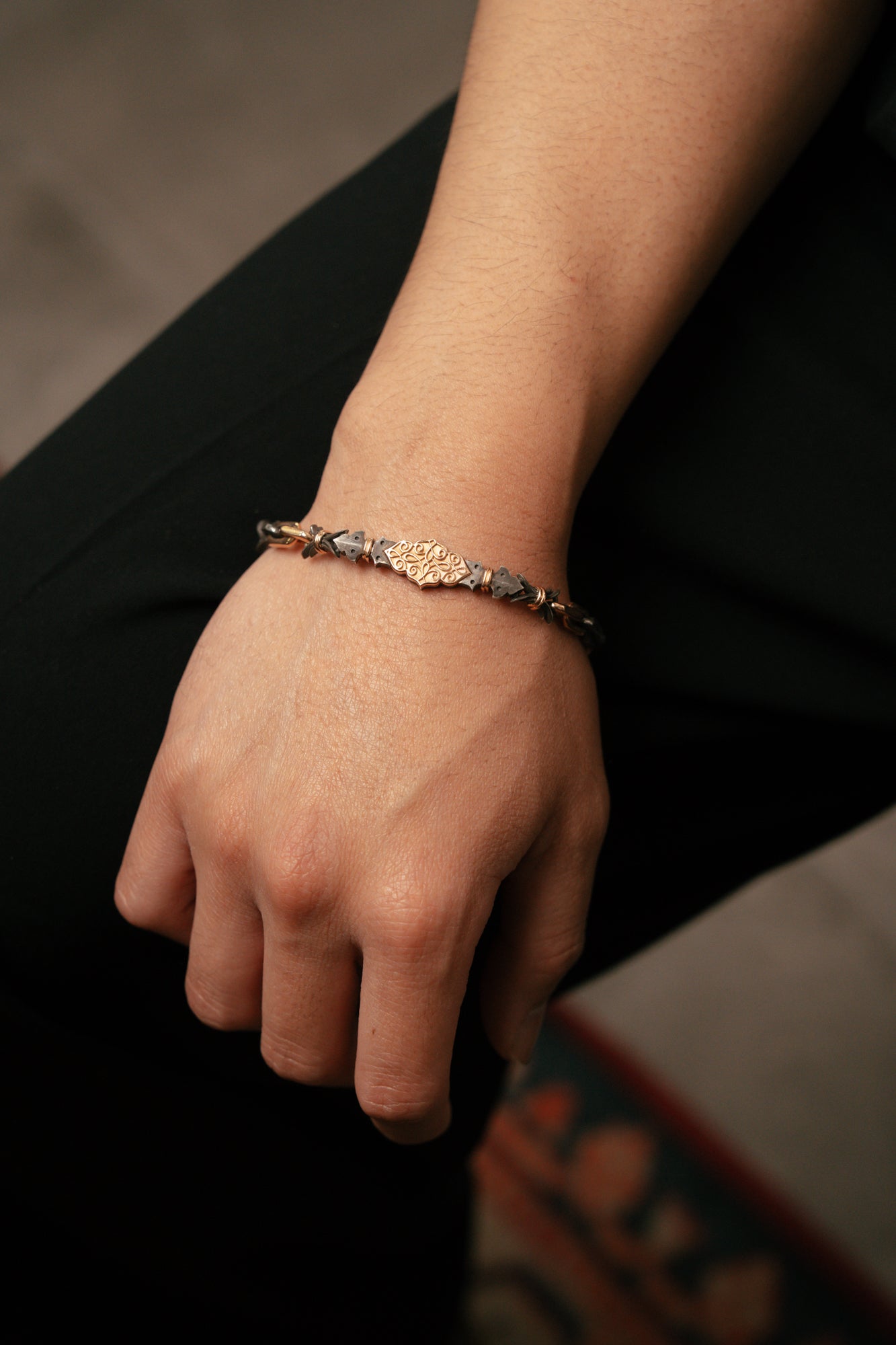 Hand wearing a bracelet with stones on a blurred background