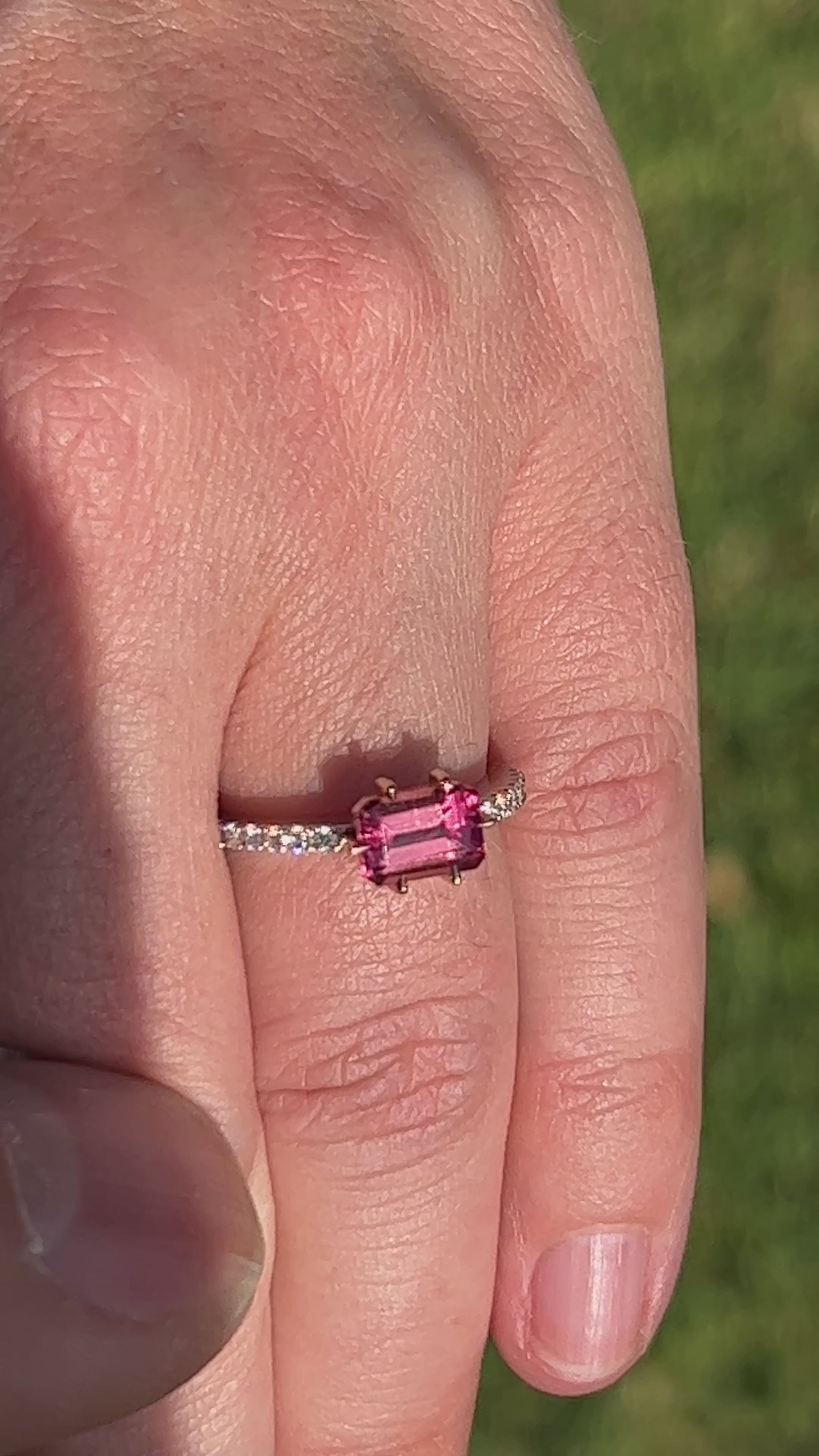 Video Of Hand wearing a ring with a pink gemstone.