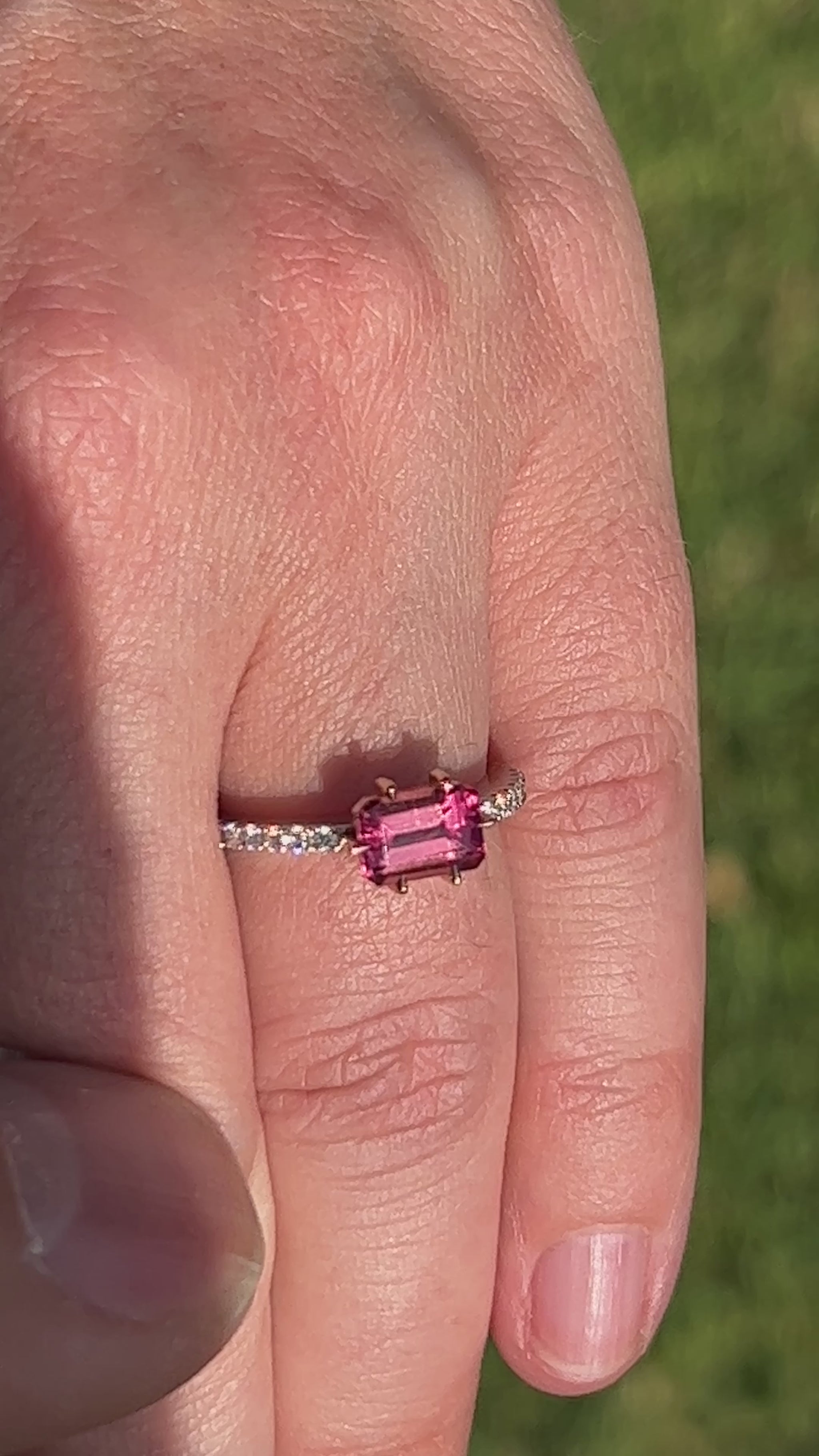 Video Of Hand wearing a ring with a pink gemstone.