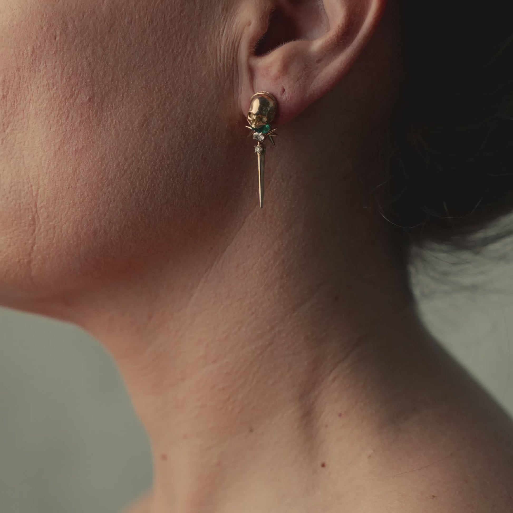 Video of model wearing skull diamond and emerald earring