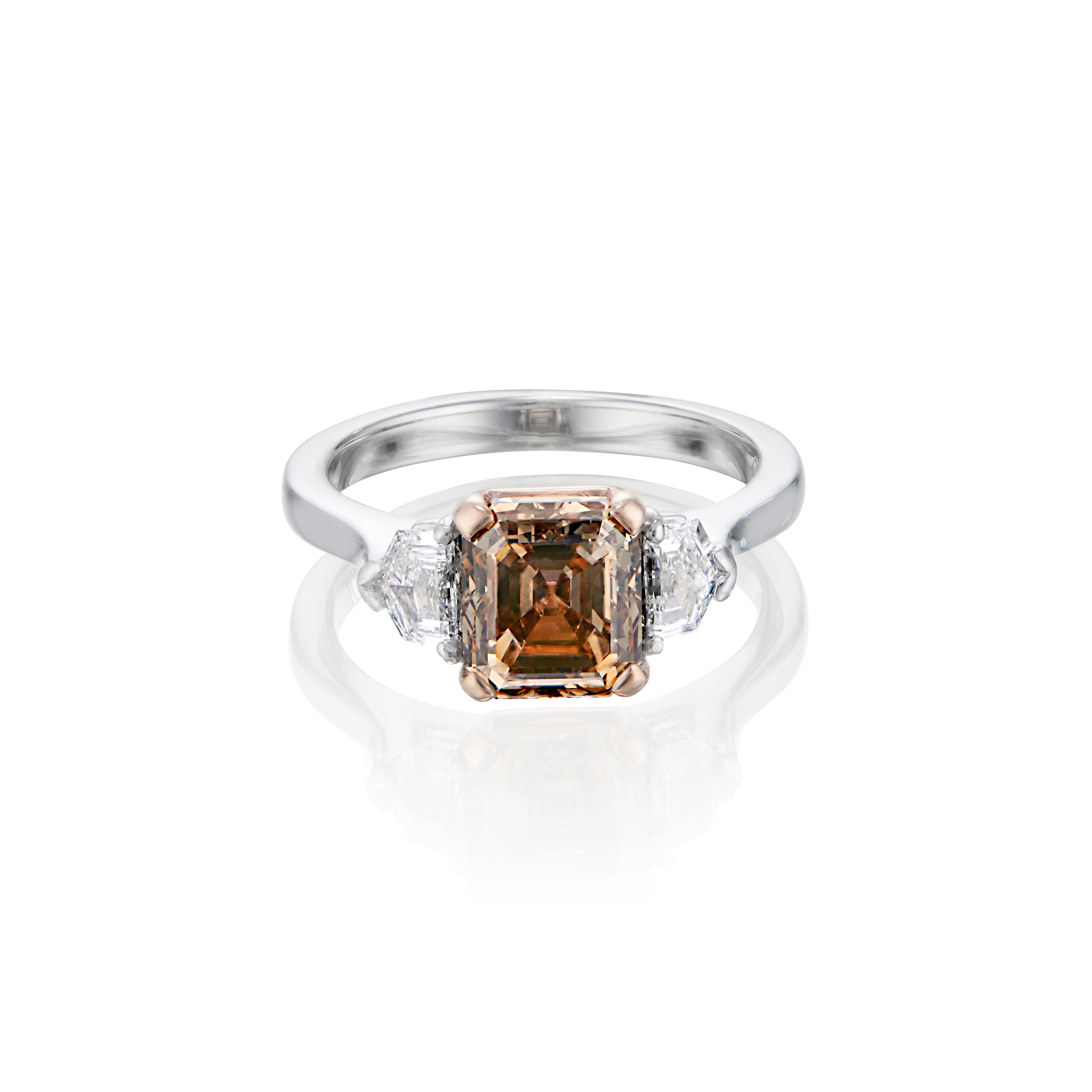 White gold ring with a central Asscher cut champagne diamond flanked by two smaller white diamonds.