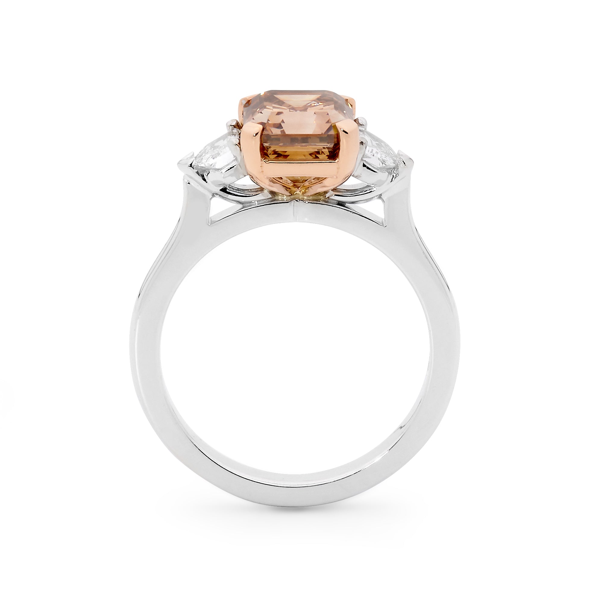 White gold ring with a central Asscher-cut peach champagne diamond flanked by two smaller diamonds.