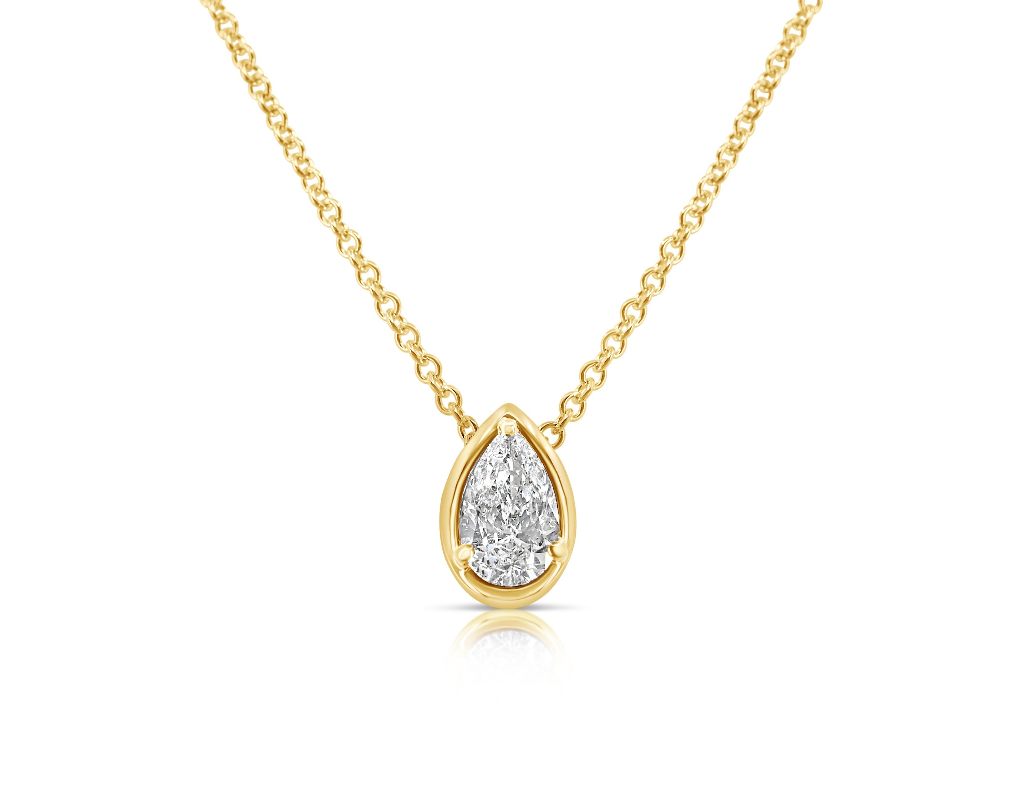 Front view of vertical pear-shaped single solitaire diamond necklace pointed up. The diamond is set in a yellow-gold pear-shaped beveled setting, fixed with 3 rounded prongs. The yellow-gold round-link chain connects at the back of the setting near the point. 