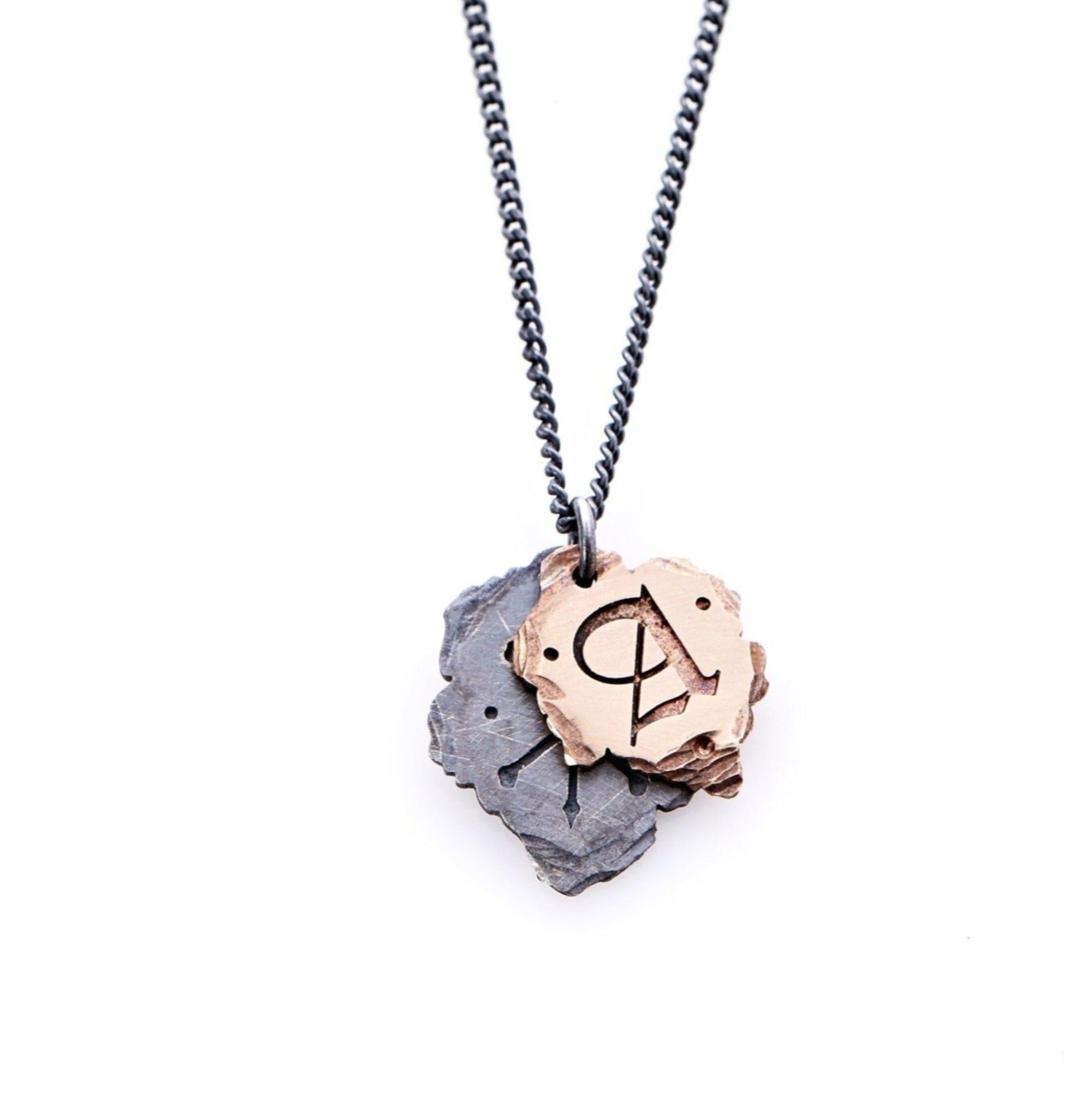 Bespoke Initial Necklace with the top rose gold plate pulled aside, partially revealing the bottom oxidized sterling silver plate. Both plates dangle from a single silver ring that connects to the curbed chain.