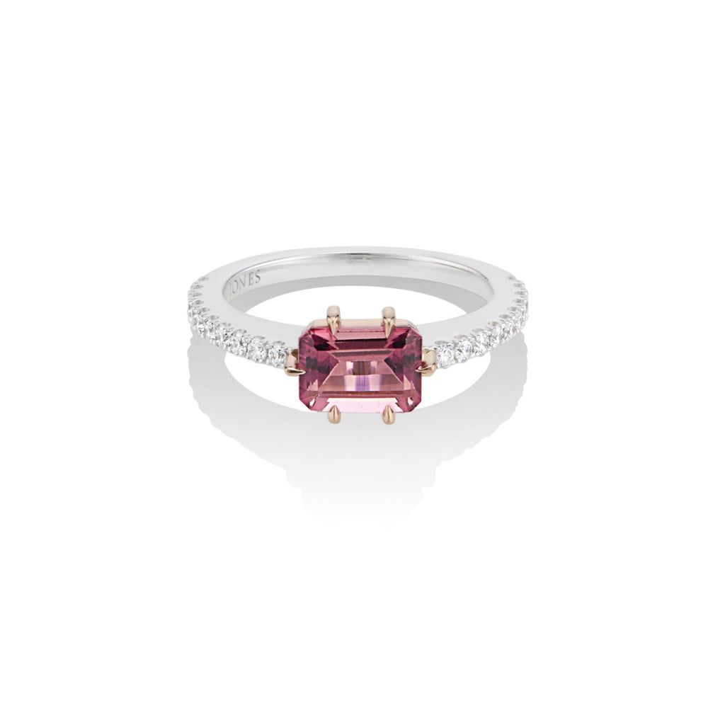 Top view of alternative pink tourmaline and diamond engagement ring. The pink tourmaline center stone is fixed with a rose gold 6-prong setting, and mounted atop a U-cut diamond pave band in white gold. The interior band engraving reads, “Harlin Jones.” 