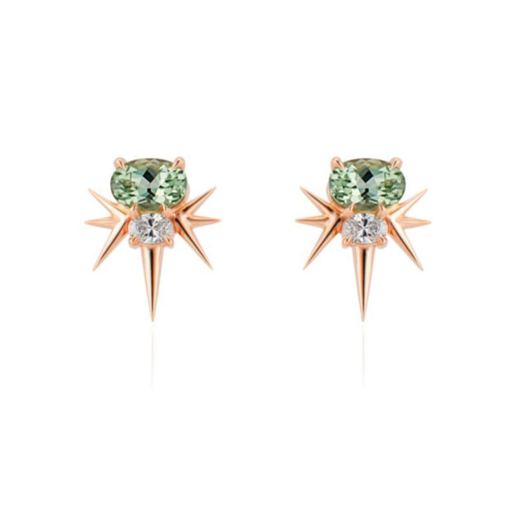  Front view of rose gold spike earrings, each featuring 1 horizontal oval-shaped green tourmaline stone with 1 oval-shaped diamond below. 7 rose gold spikes extend out from the diamond, 3 on either side and 1 slightly longer spike pointed down. 