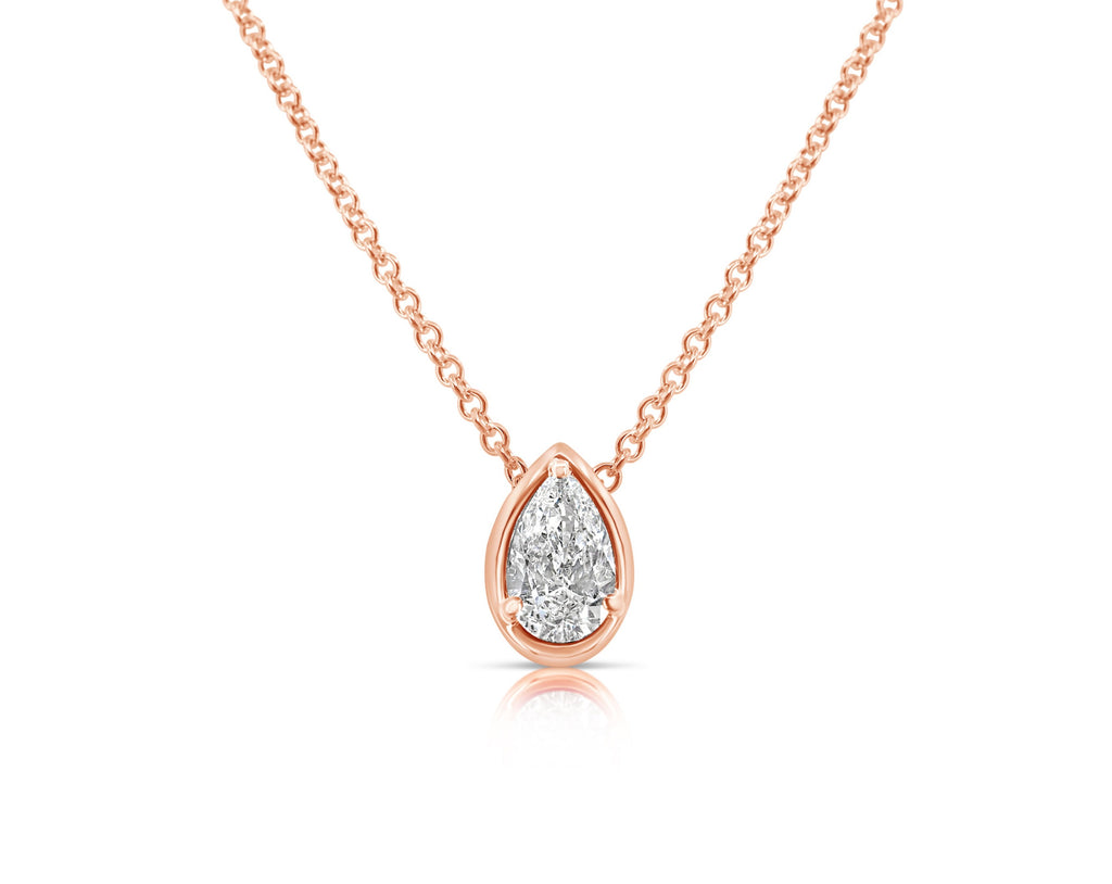  Front view of vertical pear-shaped diamond pendant necklace pointed up. The diamond is set in a rose gold pear-shaped beveled setting, fixed with 3 rounded prongs. The rose gold round-link chain connects at the back of the setting near the point.