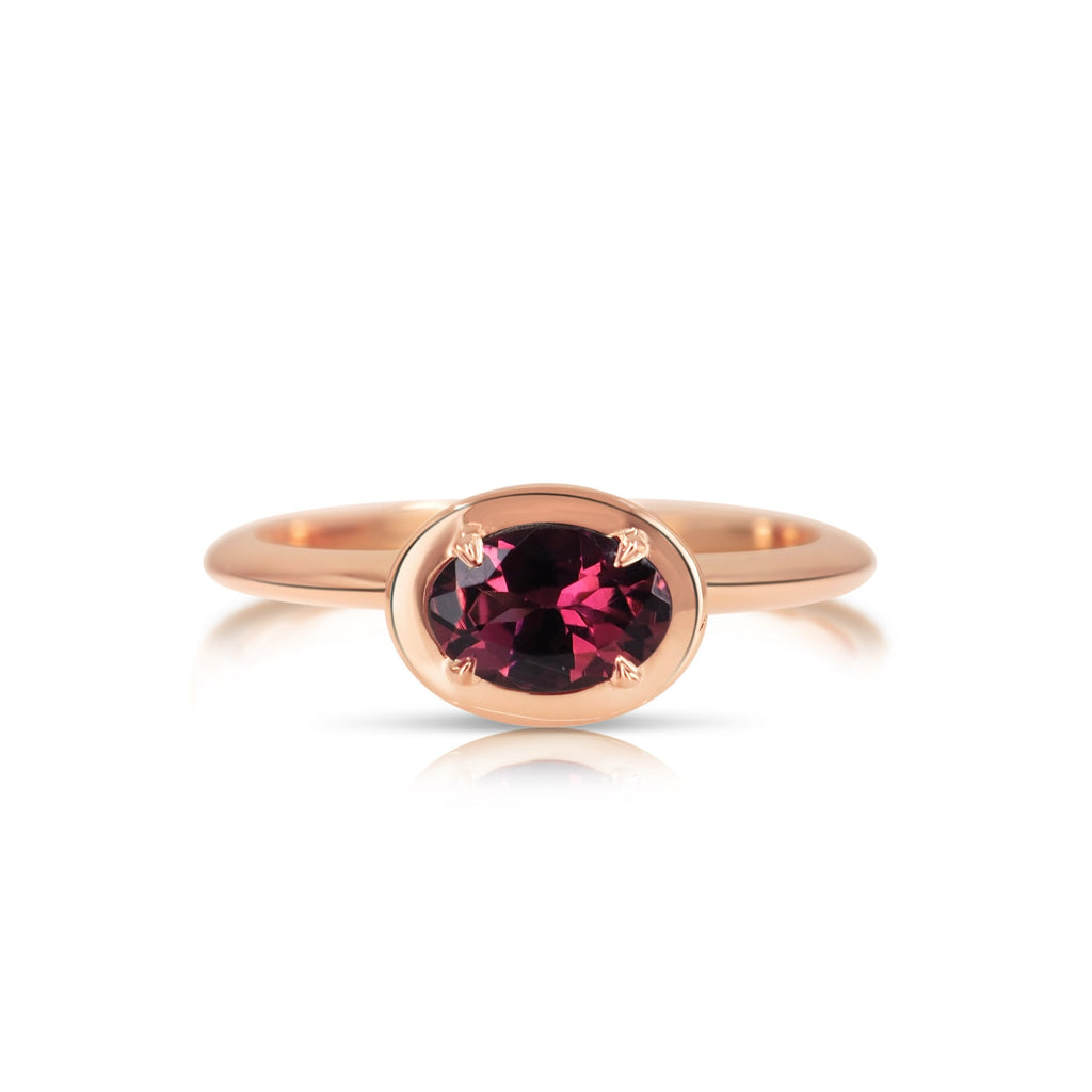 Top view of the hand-crafted pink tourmaline filigree ring. The oval-shaped pink tourmaline gemstone is fixed with 4 prongs and set in a beveled oval-shaped rose gold basket that compliments the beveled band.