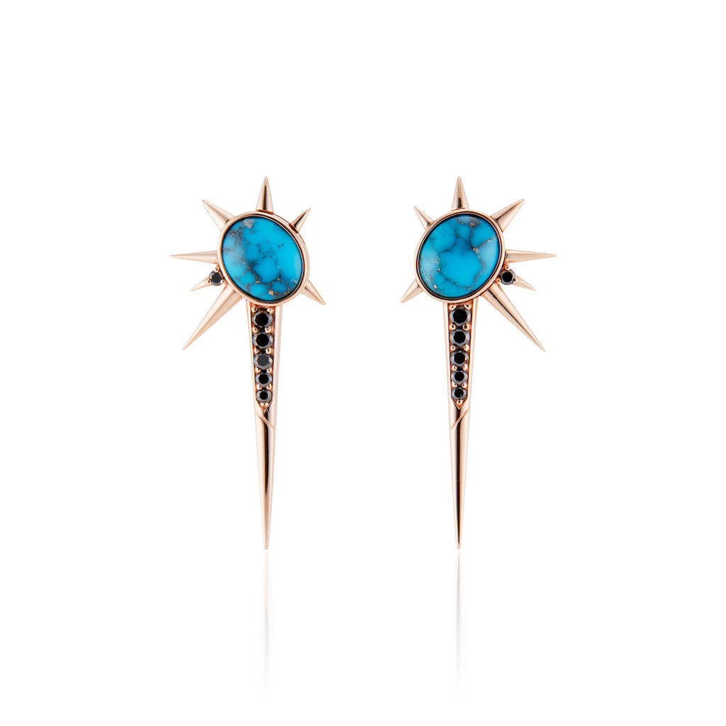 Front view. Spike drop earrings, each with 1 tilted oval-shaped turquoise stone. 8 rose gold spikes of varying lengths in an abstract star pattern; 1 long black diamond encrusted spike pointed down, 1 black diamond at the base of a short spike.