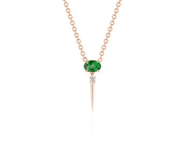  Front view of tsavorite drop necklace. A horizontal oval-shaped tsavorite is fixed with 4 prongs to a rose gold round-link chain. Below this, a single link connects to a small round diamond with a dramatic rose gold spike dropping down. 