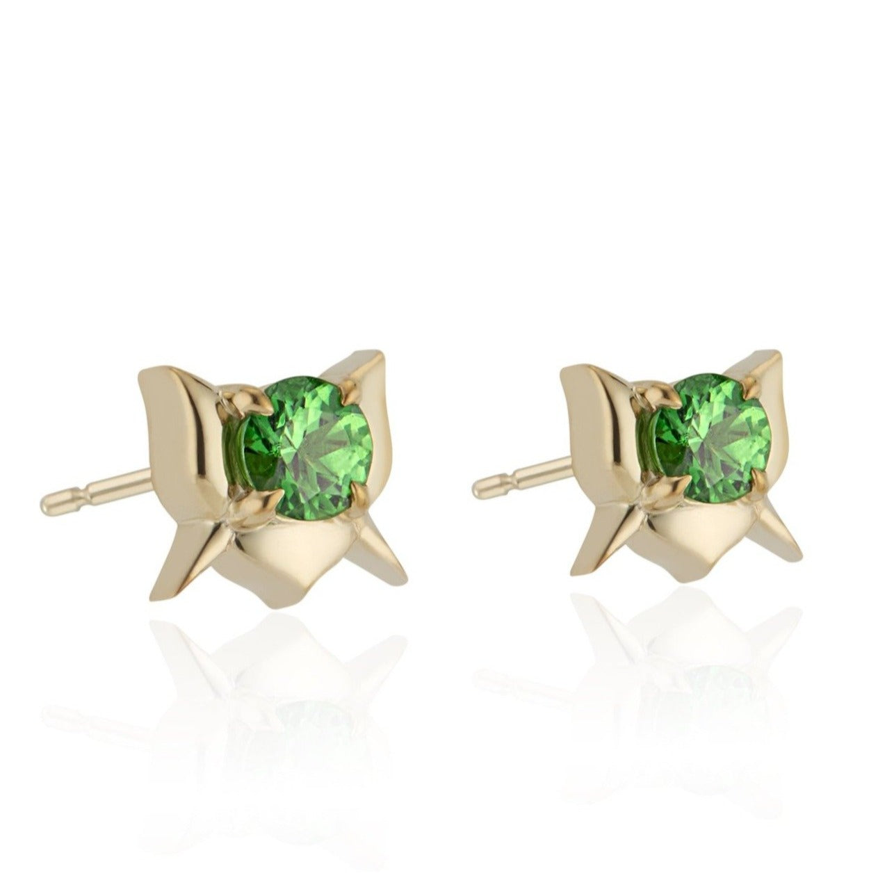 Gold earrings with green gemstones on a white background.