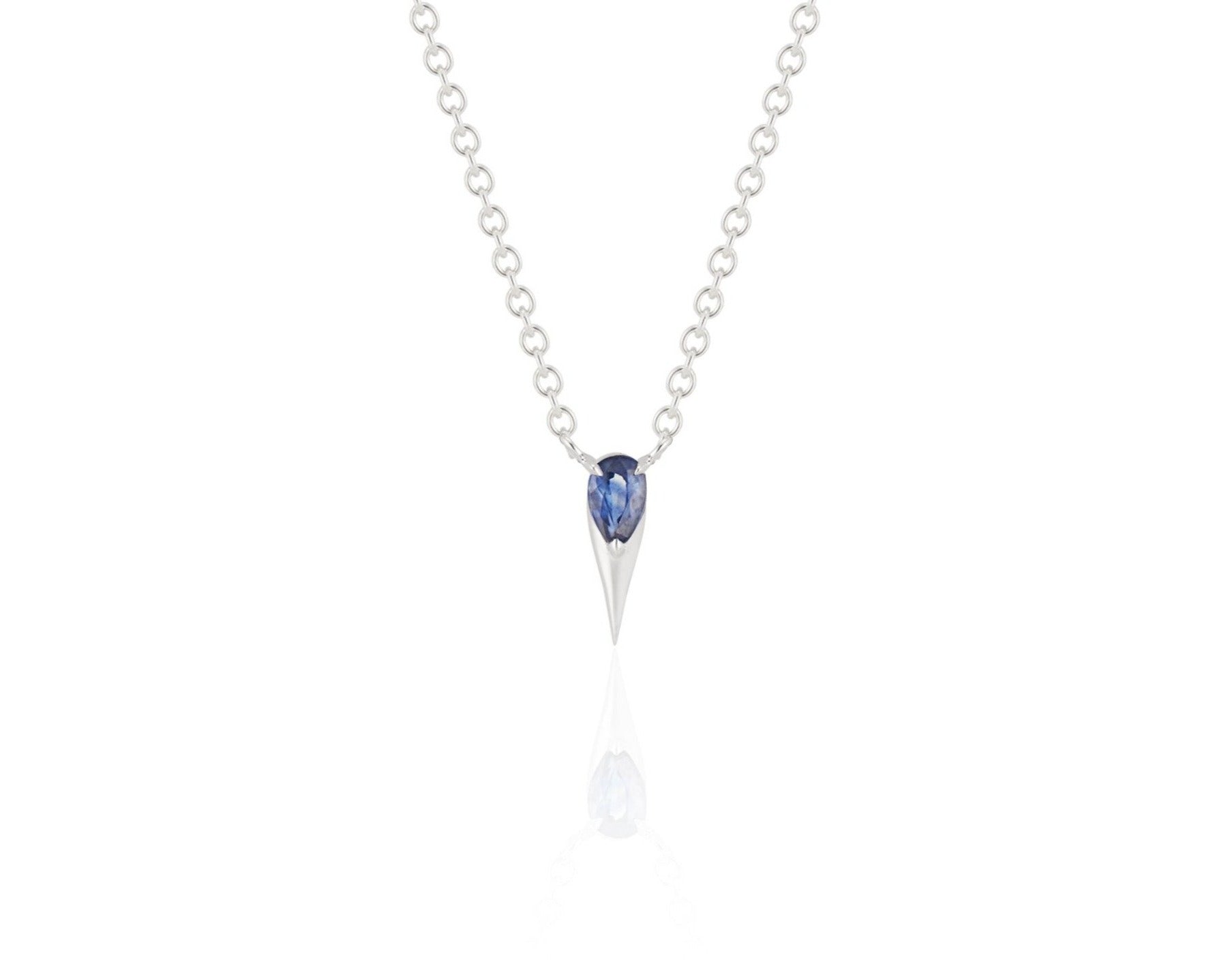 Front view of unique blue sapphire pendant necklace connected to a white gold round-link chain by 2 angled white gold prongs. The pear-shaped blue sapphire stone is set at the top of a white gold spike that drops below, forming a water droplet shape. 
