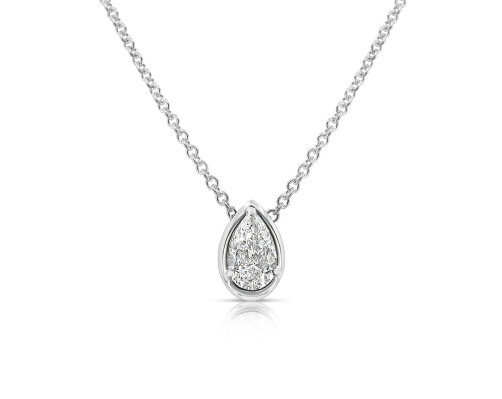 Front view of vertical pear-shaped diamond pendant necklace pointed up. The diamond is set in a white gold pear-shaped beveled setting, fixed with 3 rounded prongs. The white gold round-link chain connects at the back of the setting near the point.