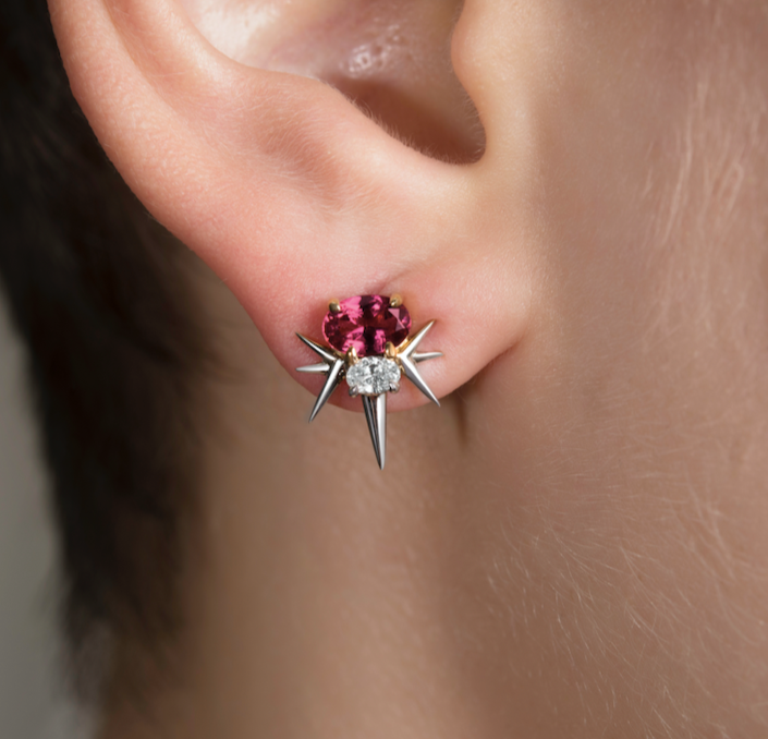 Close-up of an ear with a star-shaped earring featuring a pink tourmaline center gemstone and diamond accents.