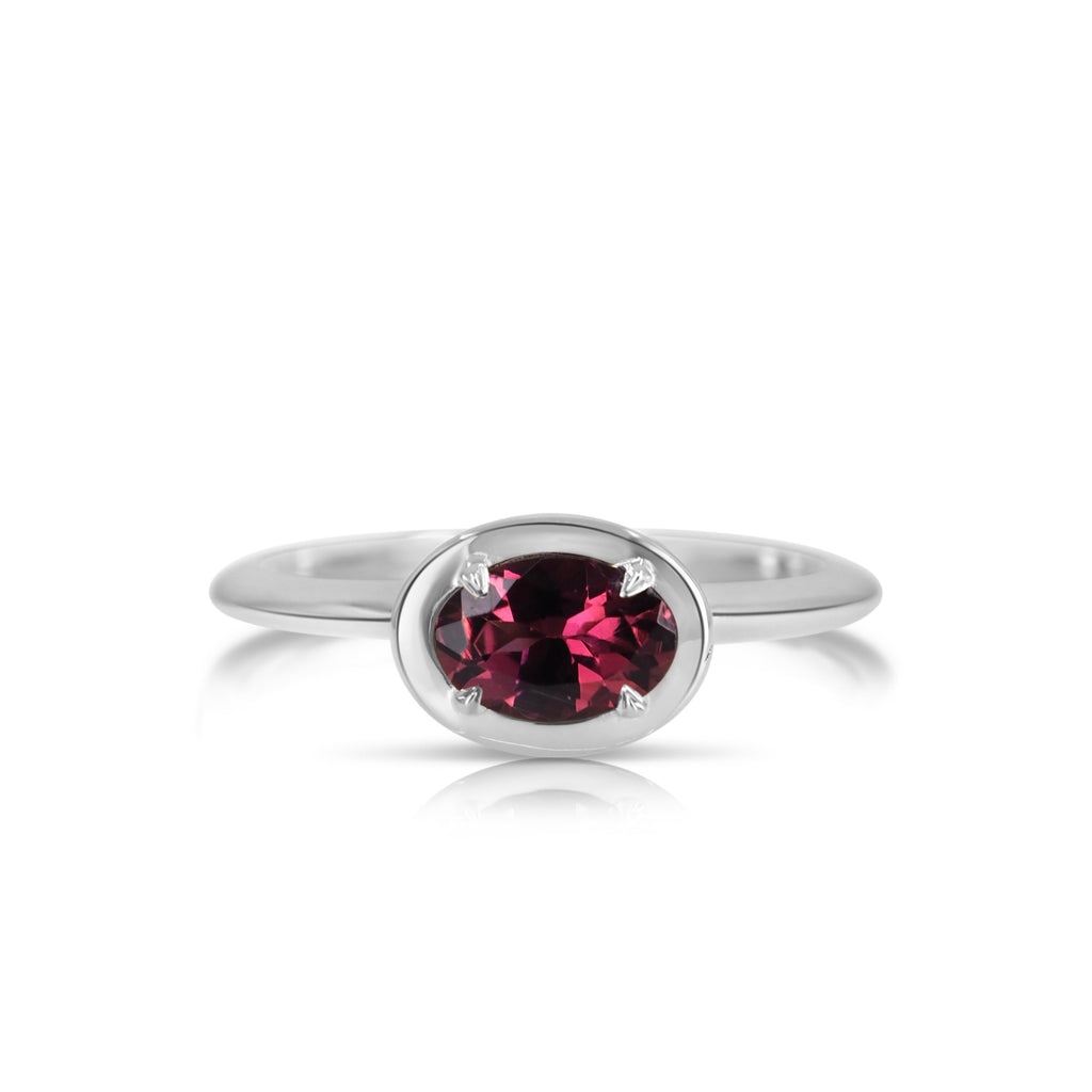 Top view of the hand-crafted pink tourmaline filigree ring. The oval-shaped pink tourmaline gemstone is fixed with 4 prongs and set in a beveled oval-shaped white gold basket that compliments the beveled band.
