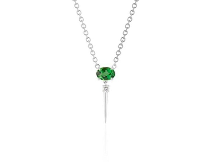  Front view of tsavorite drop necklace. A horizontal oval-shaped tsavorite is fixed with 4 prongs to a white gold round-link chain. Below this, a single link connects to a small round diamond with a dramatic white gold spike dropping down. 