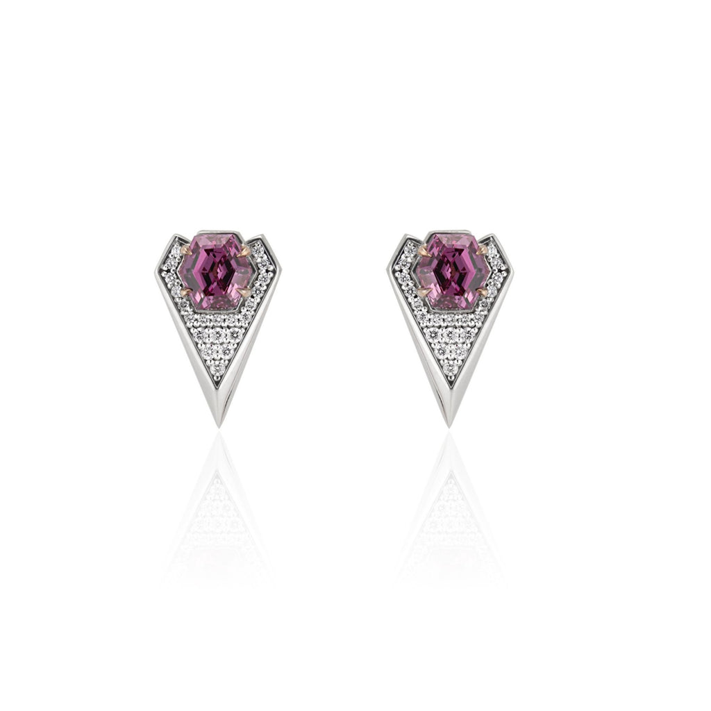 Front view of white gold drop earrings. A hexagonal pink garnet is fixed with 4 rose gold prongs at the top of a diamond encrusted geometric heart. The border is a white gold beveled edge that gradually widens towards the point at the bottom.