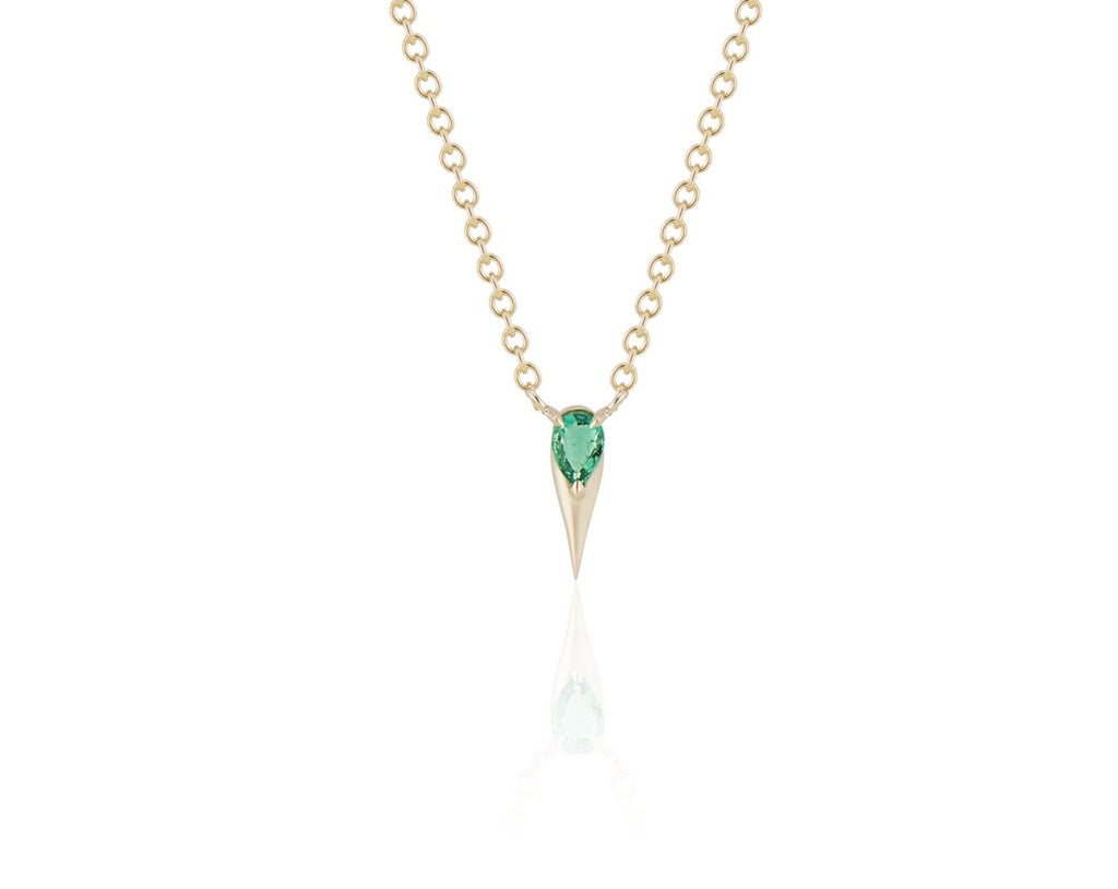 Front view of unique emerald pendant necklace connected to a yellow gold round-link chain by 2 angled yellow gold prongs. The pear-shaped emerald stone is set at the top of a yellow gold spike that drops below, forming a water droplet shape. 