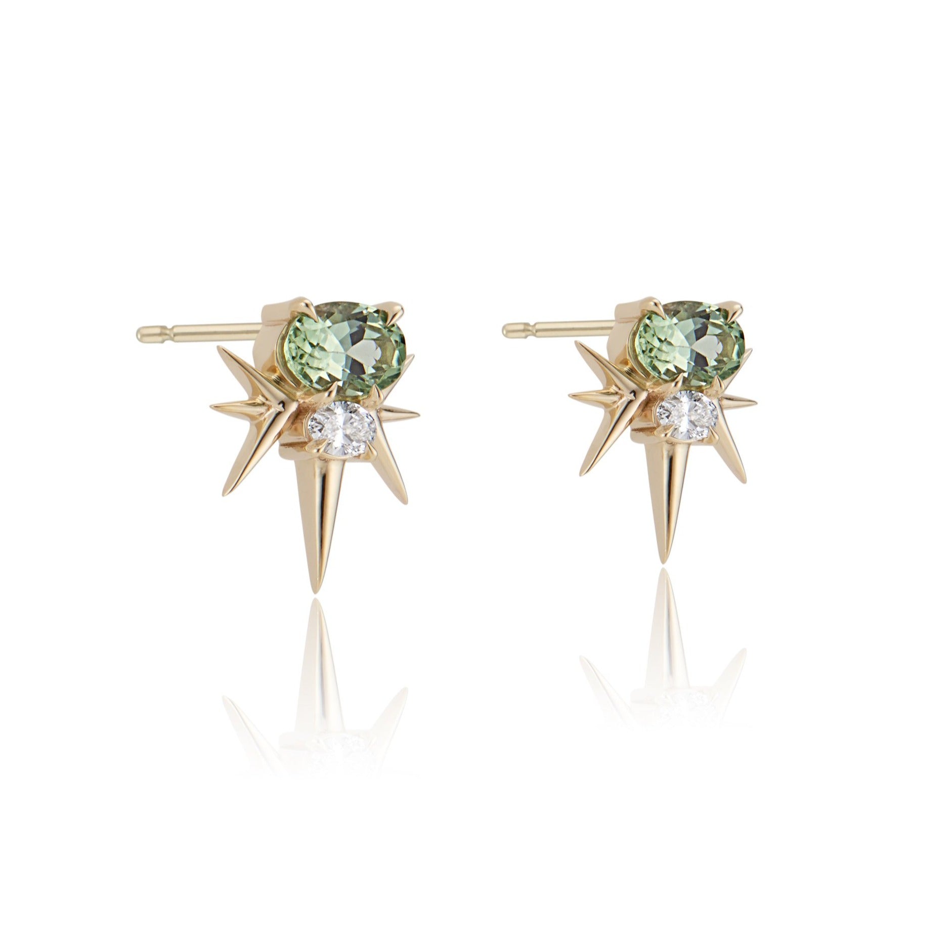 A pair of yellow gold starburst earrings with central green gemstone and diamond accents.