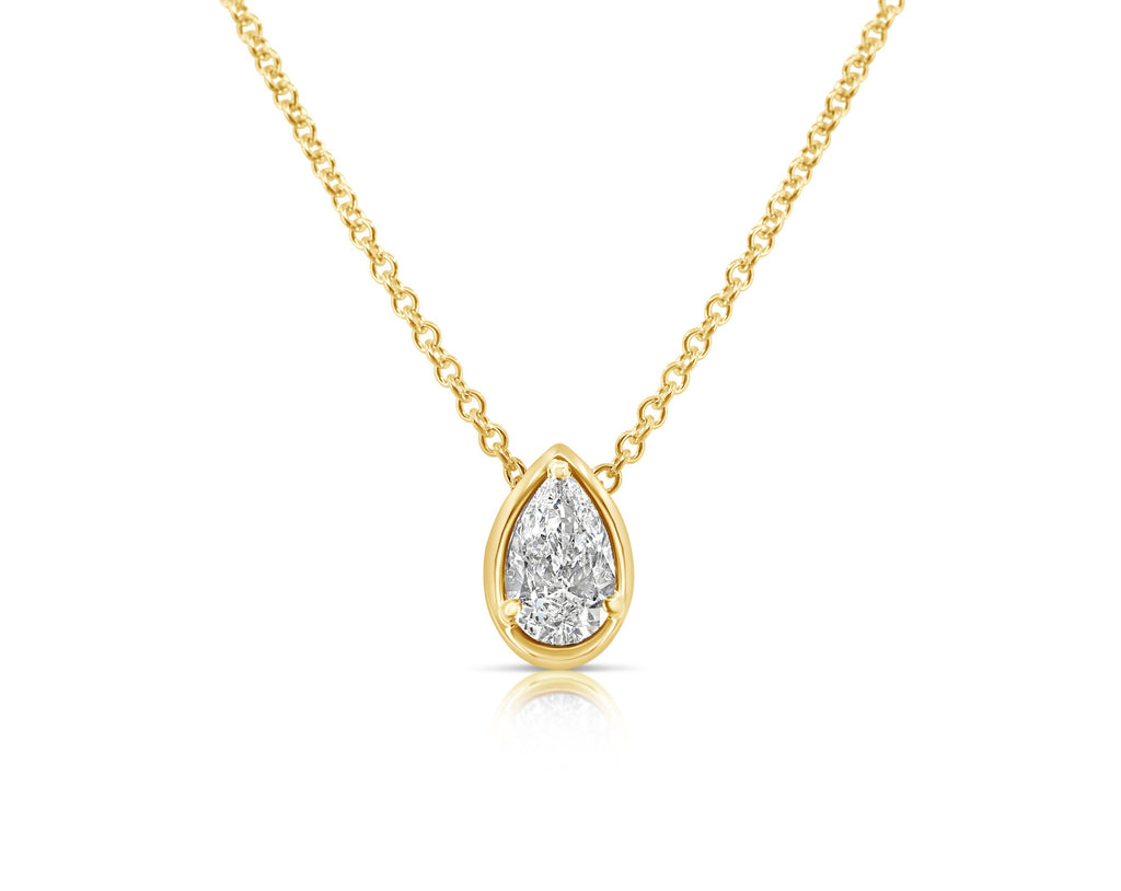 Front view of vertical pear-shaped diamond pendant necklace pointed up. The diamond is set in a yellow gold pear-shaped beveled setting, fixed with 3 rounded prongs. The yellow gold round-link chain connects at the back of the setting near the point.