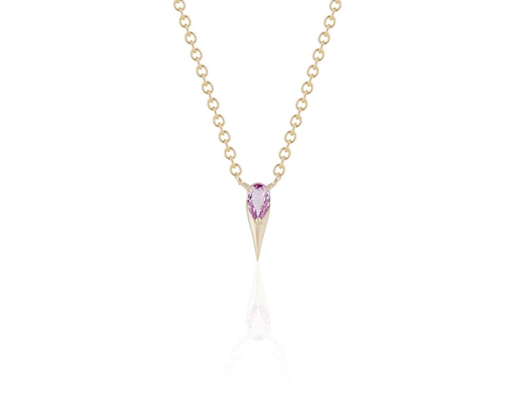 Front view of unique pink sapphire pendant necklace connected to a yellow gold round-link chain by 2 angled yellow gold prongs. The pear-shaped pink sapphire stone is set at the top of a yellow gold spike that drops below, forming a water droplet shape. 
